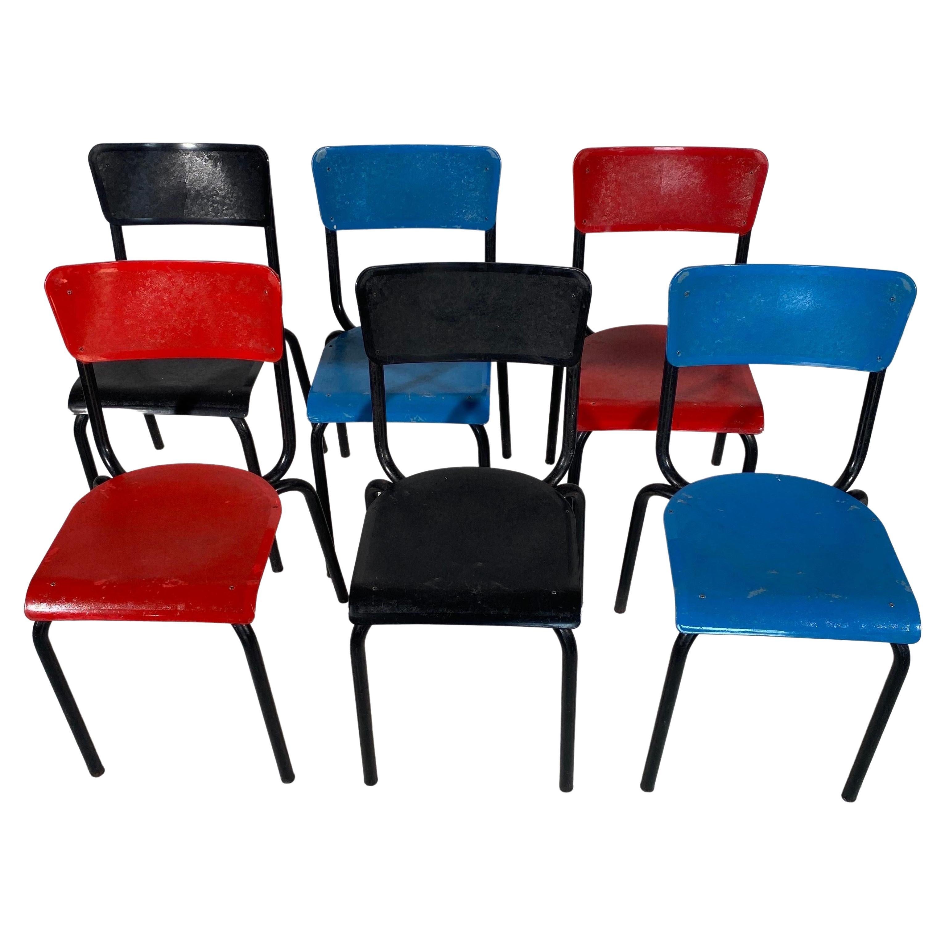 A set of six stackable chairs for the dining room, in a lovely Belgian design. They have a black lacquered metal structure and plastic seats and backs two in red and two in black and two in blue. This color and their clean design make them versatile