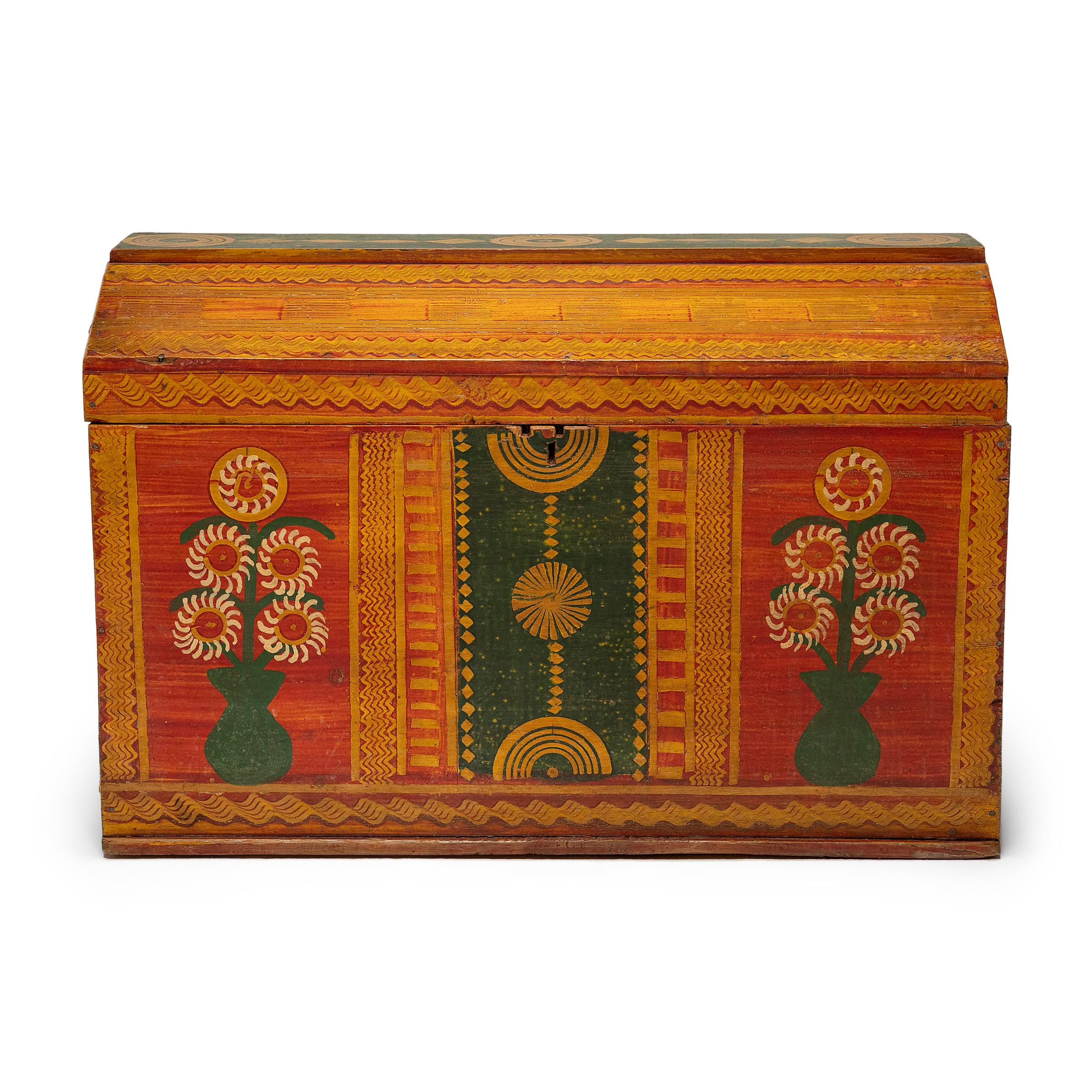 This colorful painted trunk dates to the mid-20th century and was lovingly crafted by traditional folk artisans in Guatemala. Ideal as a blanket chest, the wooden trunk is crafted of pine board and lavishly decorated with floral motifs in a palette