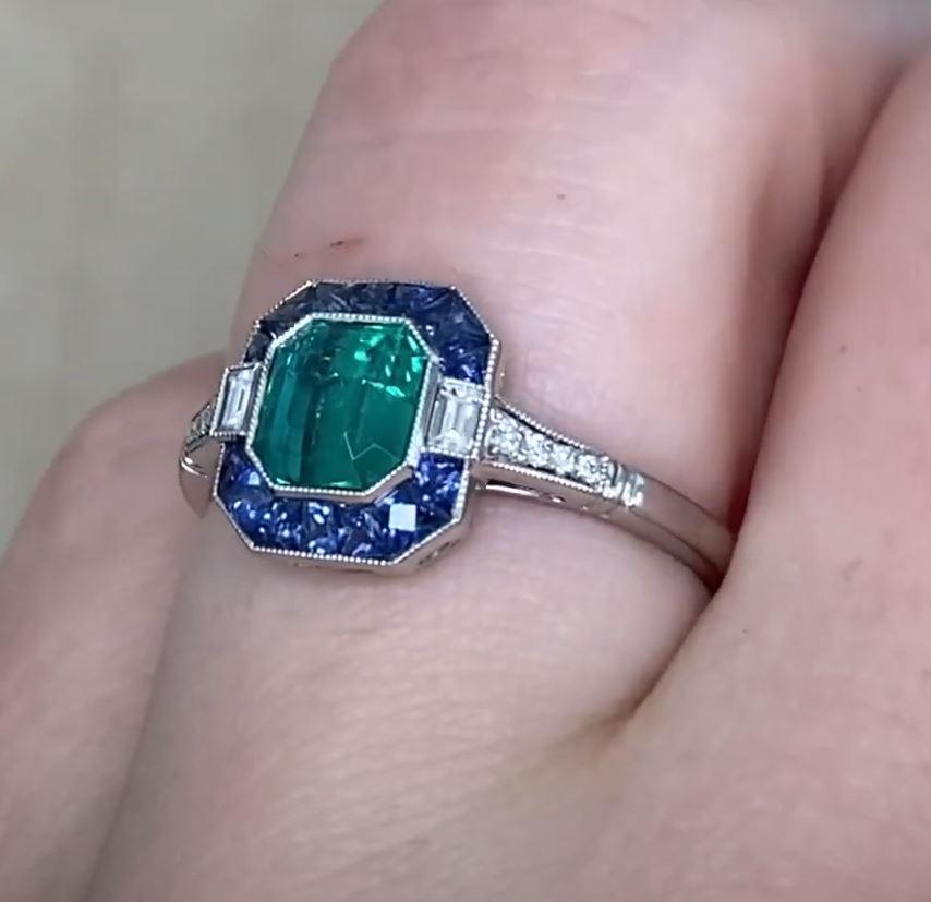 This exquisite halo ring showcases a natural approx. 0.90-carat Colombian emerald, certified by Gubelin and prized for its rare, no-oil enhancement. The emerald’s vivid green hue is elegantly framed by a halo of French-cut sapphires and baguette-cut