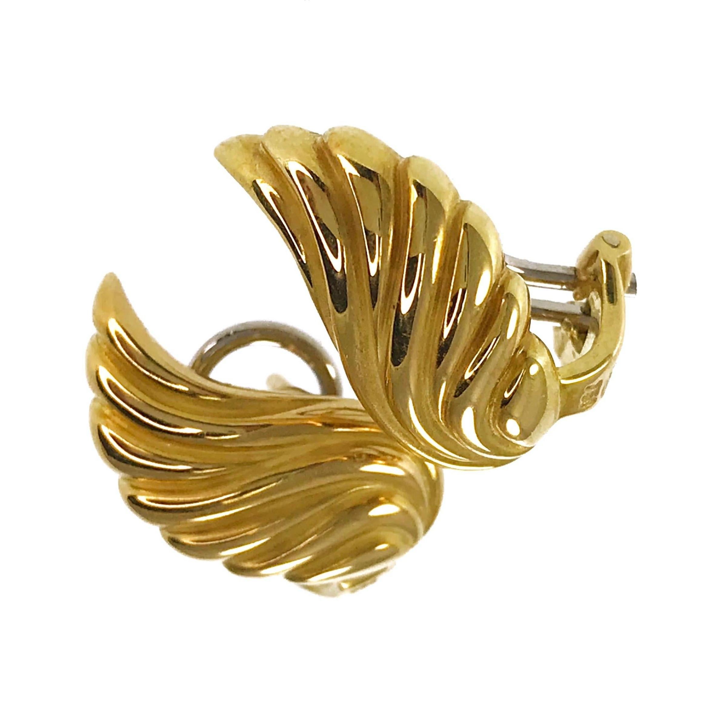 Gübelin 18 Karat Wing-Shaped Earrings. These lovely earrings consist of sculpted gold forming a wing-shaped drop earring. The earring measures 18.5mm wide x 9.6mm tall and have a short post and Omega clip back. Stamped on the bottom of the earrings