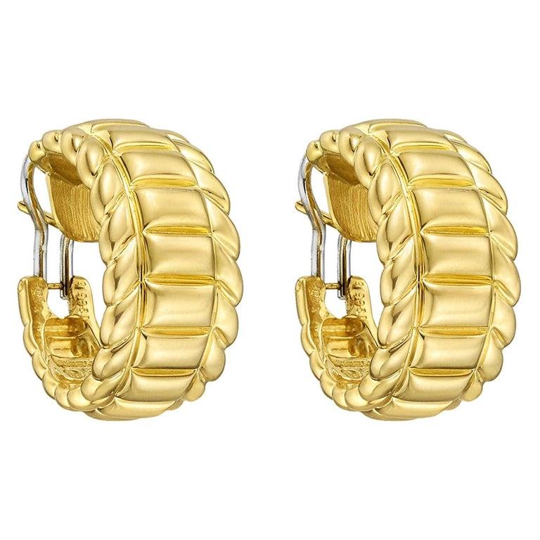 Wide hoop earrings, designed as a fluted half-hoop in polished 18k yellow gold.
 
Signed Gubelin
Omega-style clip backs with posts
0.8