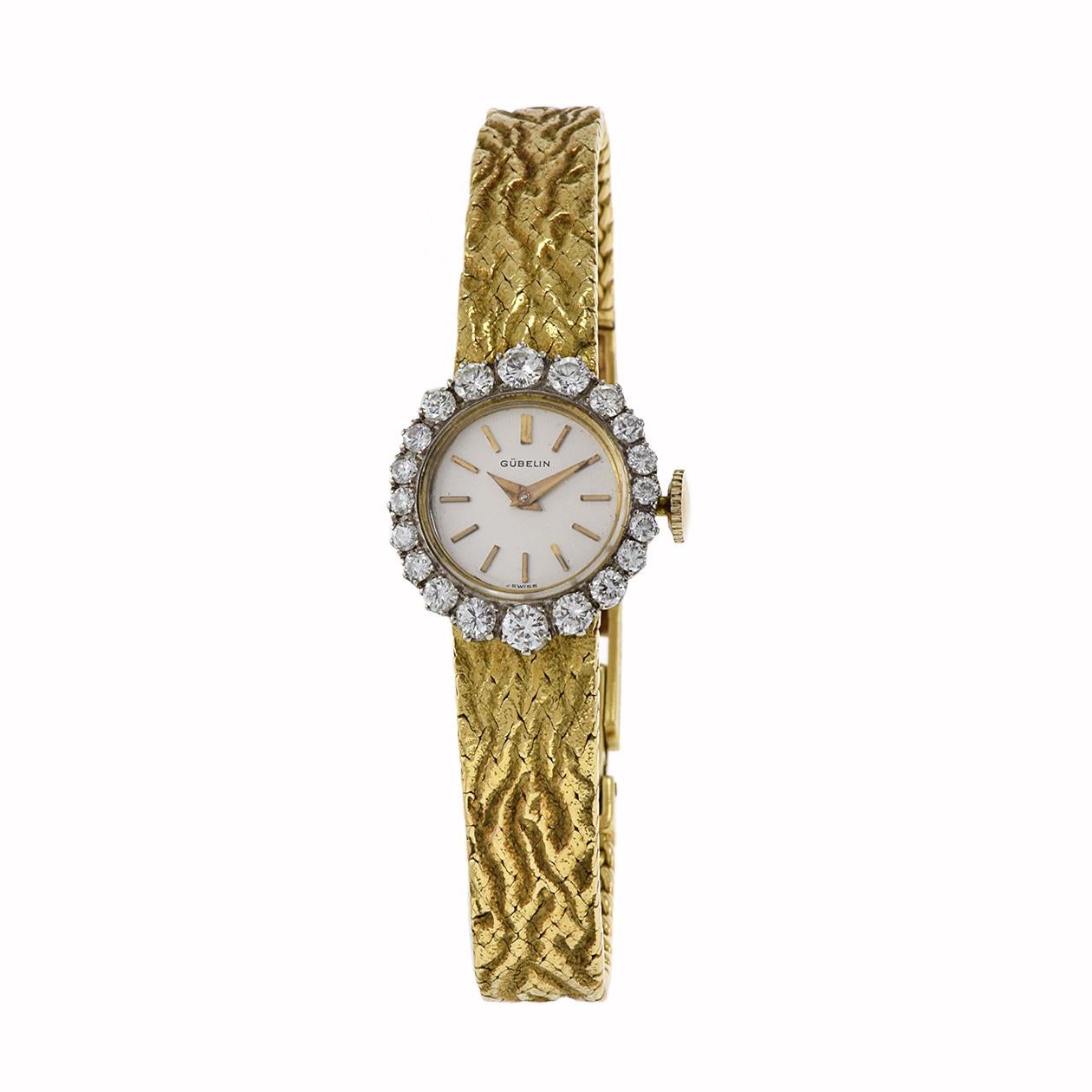 Die bezaubernde Gubelin 1960's Diamond Bezel Bracelet Watch ist eine atemberaubende Verkörperung von Luxus und Raffinesse. Der mit viel Liebe zum Detail gefertigte Zeitmesser mit 19-mm-Gehäuse und -Armband aus 18-karätigem Gold strahlt mit jedem
