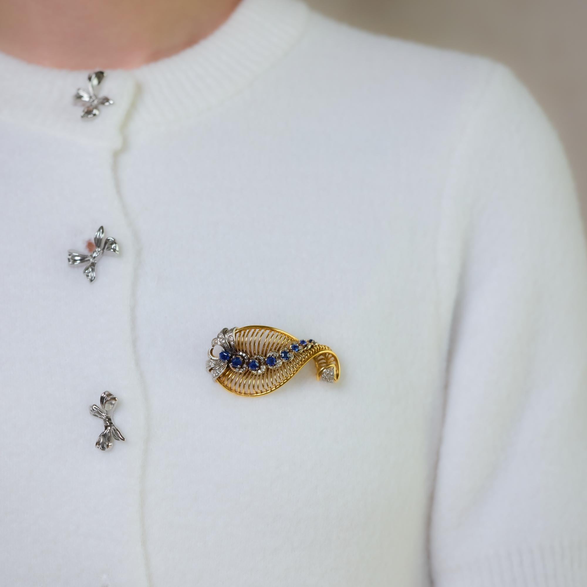 This exquisite mid-century Gubelin brooch showcases eight hexagon-cut blue sapphires totaling approximately 3 carats, accented by 54 single cut diamonds totaling approximately 0.70 carats, G color, VS-SI clarity. Crafted in 18k yellow gold and