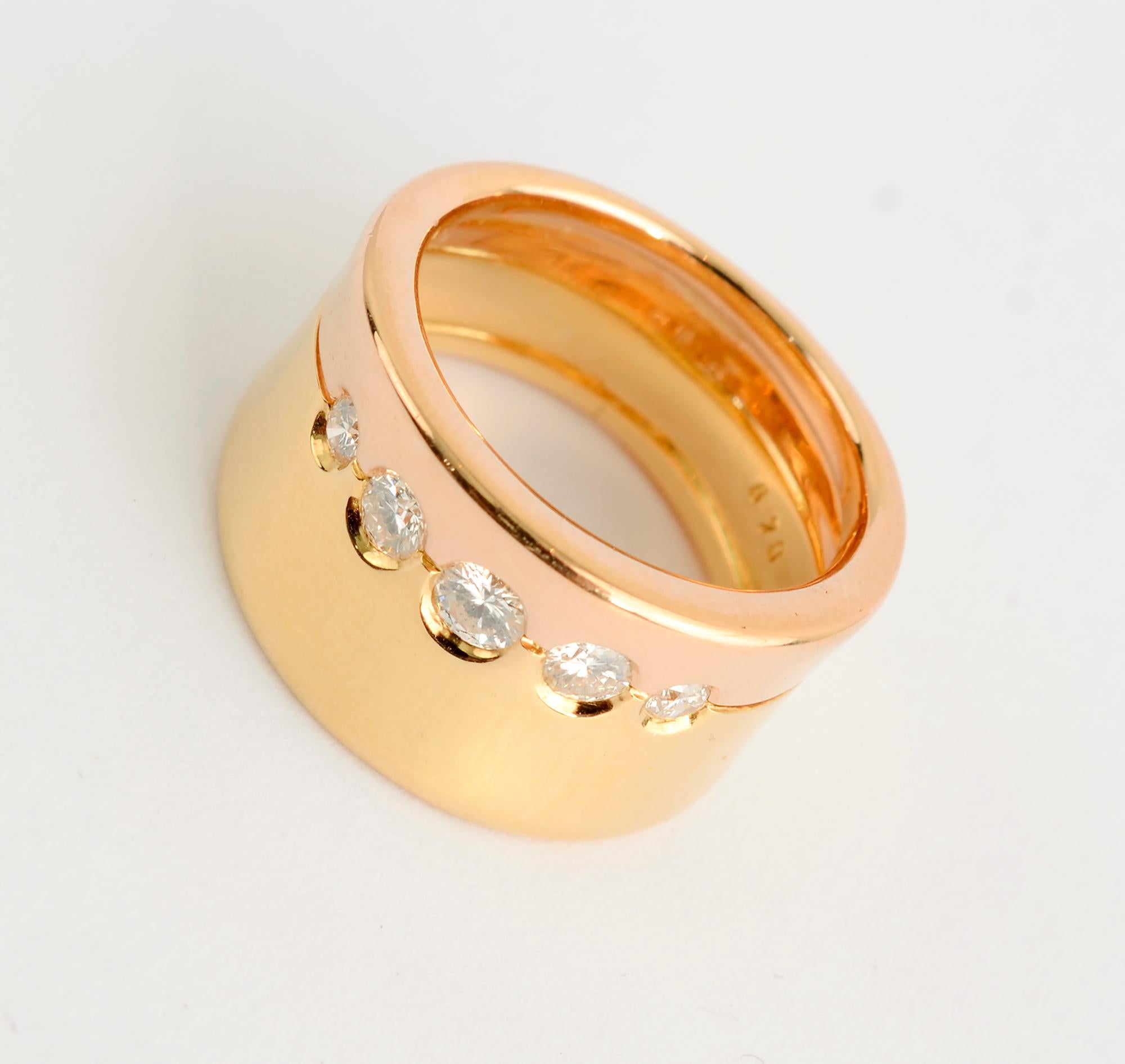Stylish and unusual yellow and pink gold ring by Gubelin. The yellow portion of the band is wider than the pink. Between them are five graduated size diamonds, the largest of which is .25 carats. The two bands of gold are slightly concave. The ring