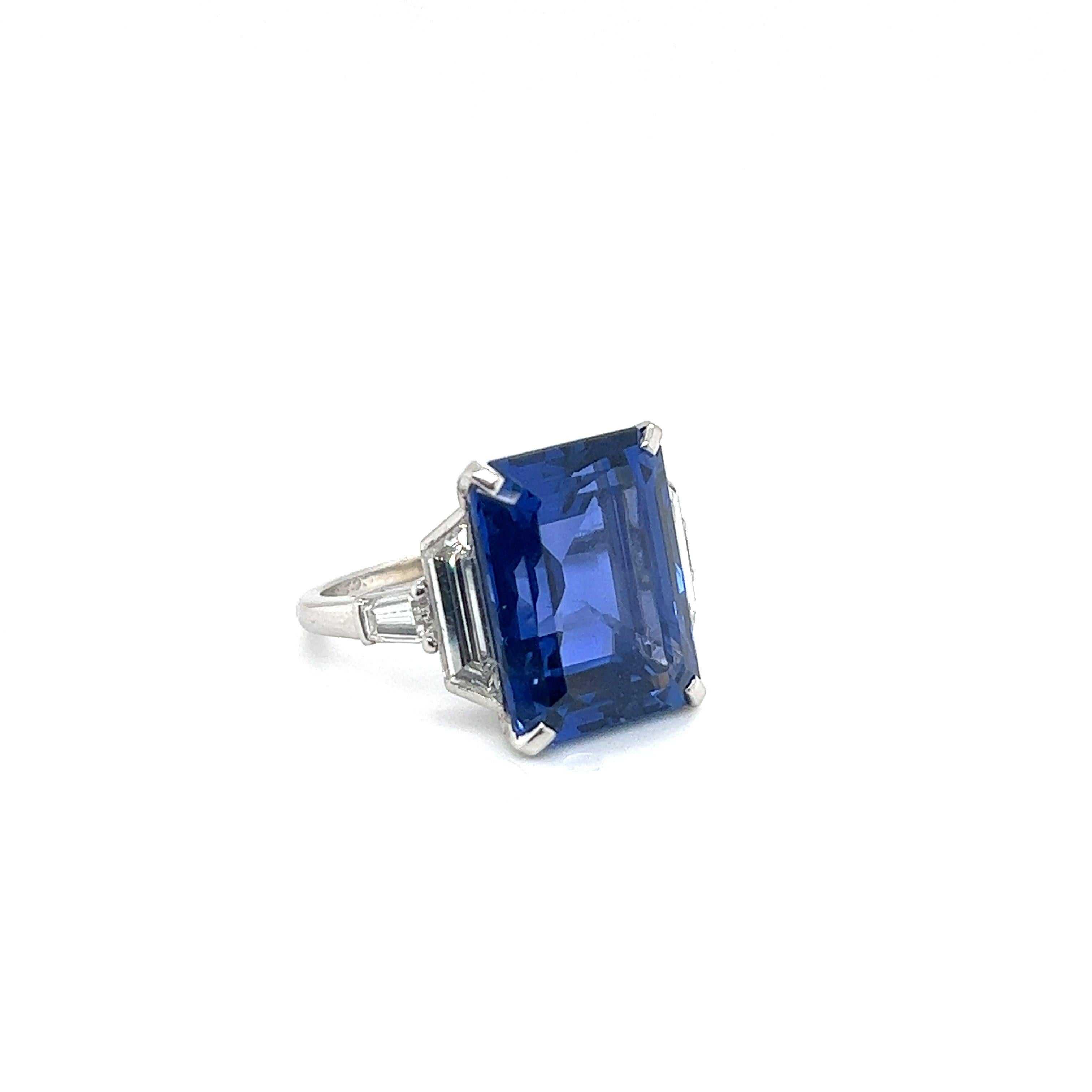 Splendid 16.50 carat Ceylon sapphire and diamond solitaire engagement ring.
Elegant ring centering upon a vibrant blue, octagonal sapphire of approximately 16.50 carats, flanked by two trapezoid-shaped diamonds and the ring shoulders enhanced with 2