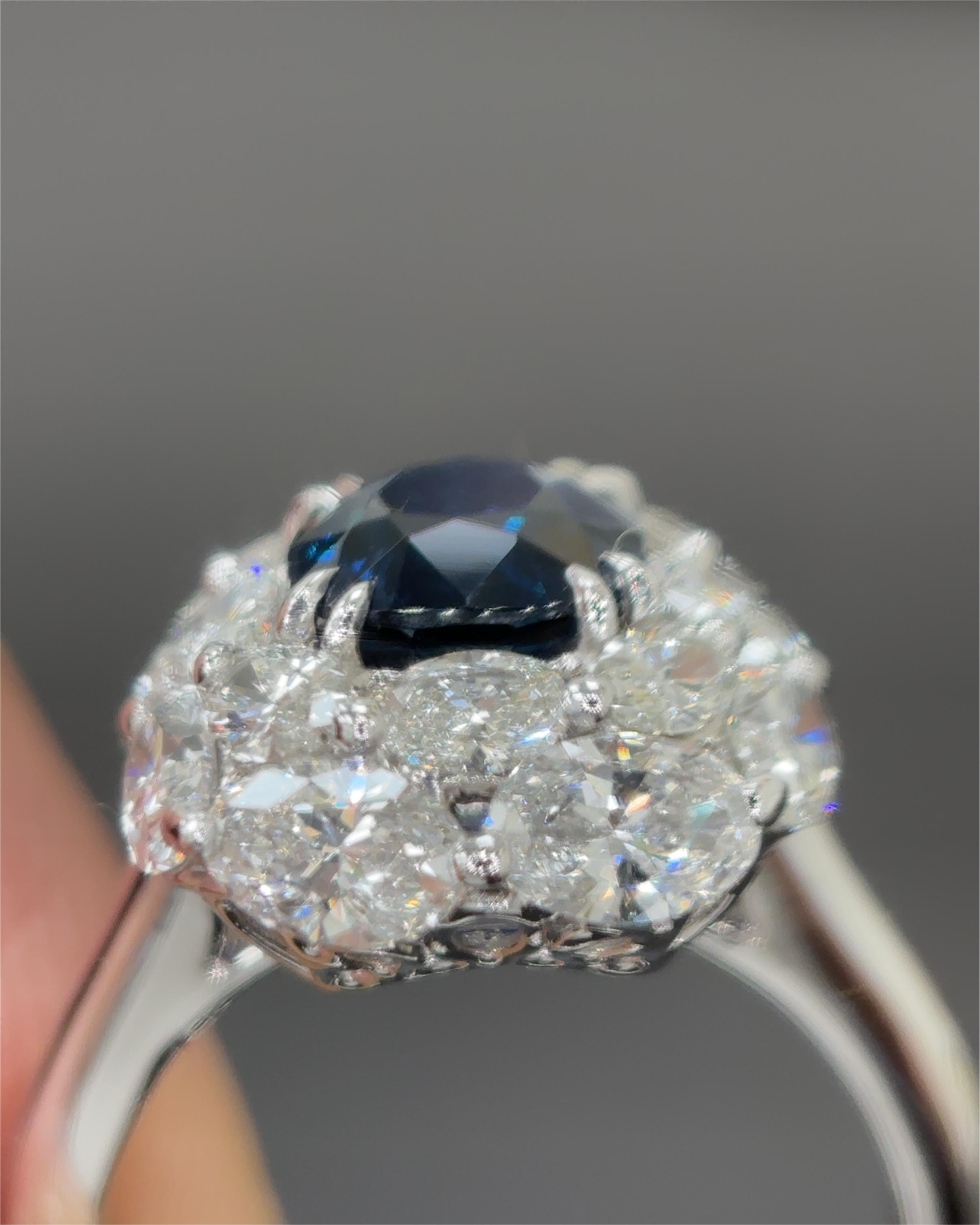 Cette bague exquise met en valeur un saphir birman sans chaleur de 2,11 carats certifié par Gubelin, une pierre précieuse d'une rareté et d'un prestige extraordinaires. Sertie en platine et entourée d'un halo scintillant de diamants de taille mixte,