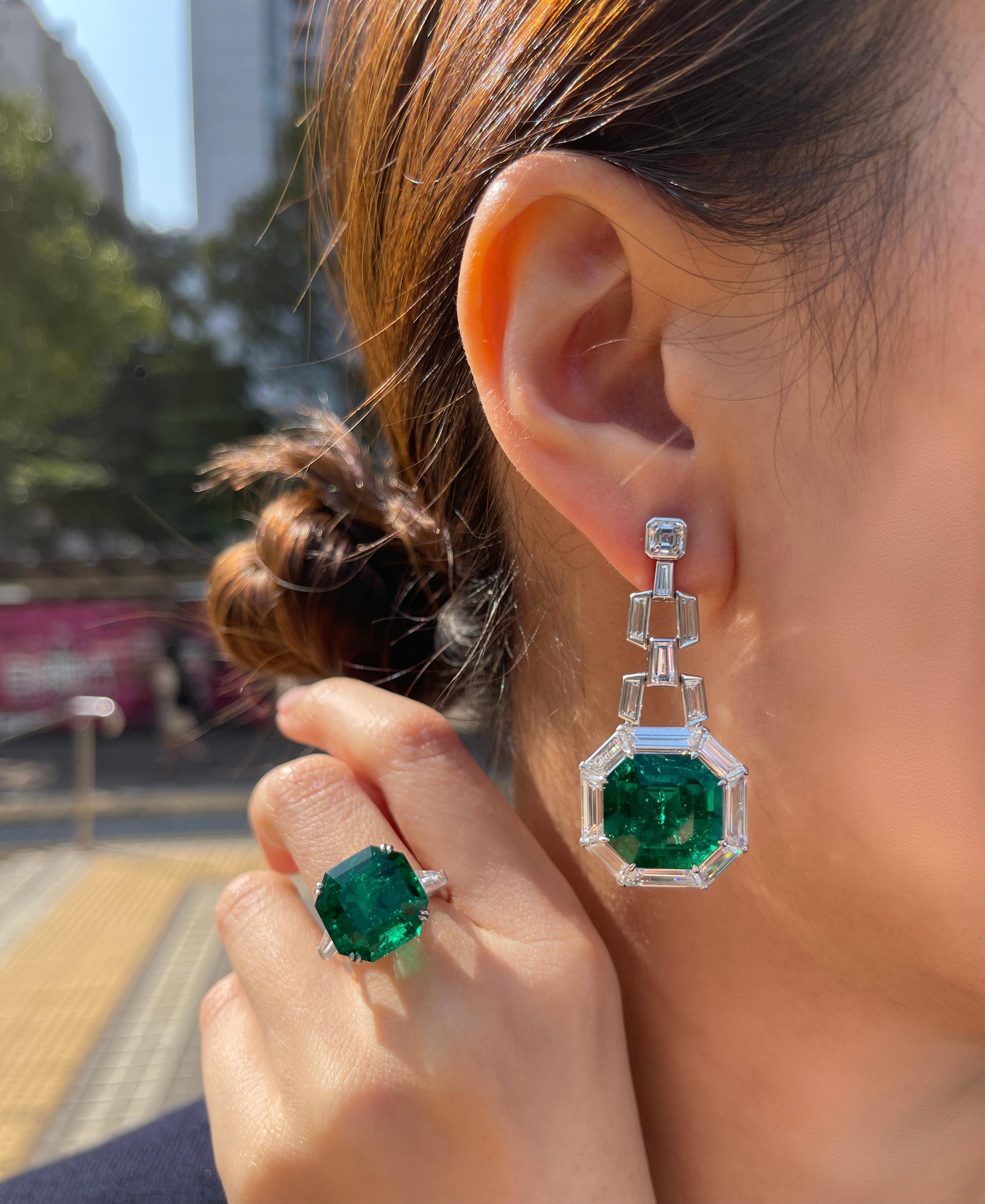 This piece is available for custom order only. 

Art Deco Style! These Colombian Emerald earrings feature octagonal shape minor oil emeralds over 12 carats each. The emeralds are surrounded by 11.54 carats of trapez, tapper and round cut diamonds