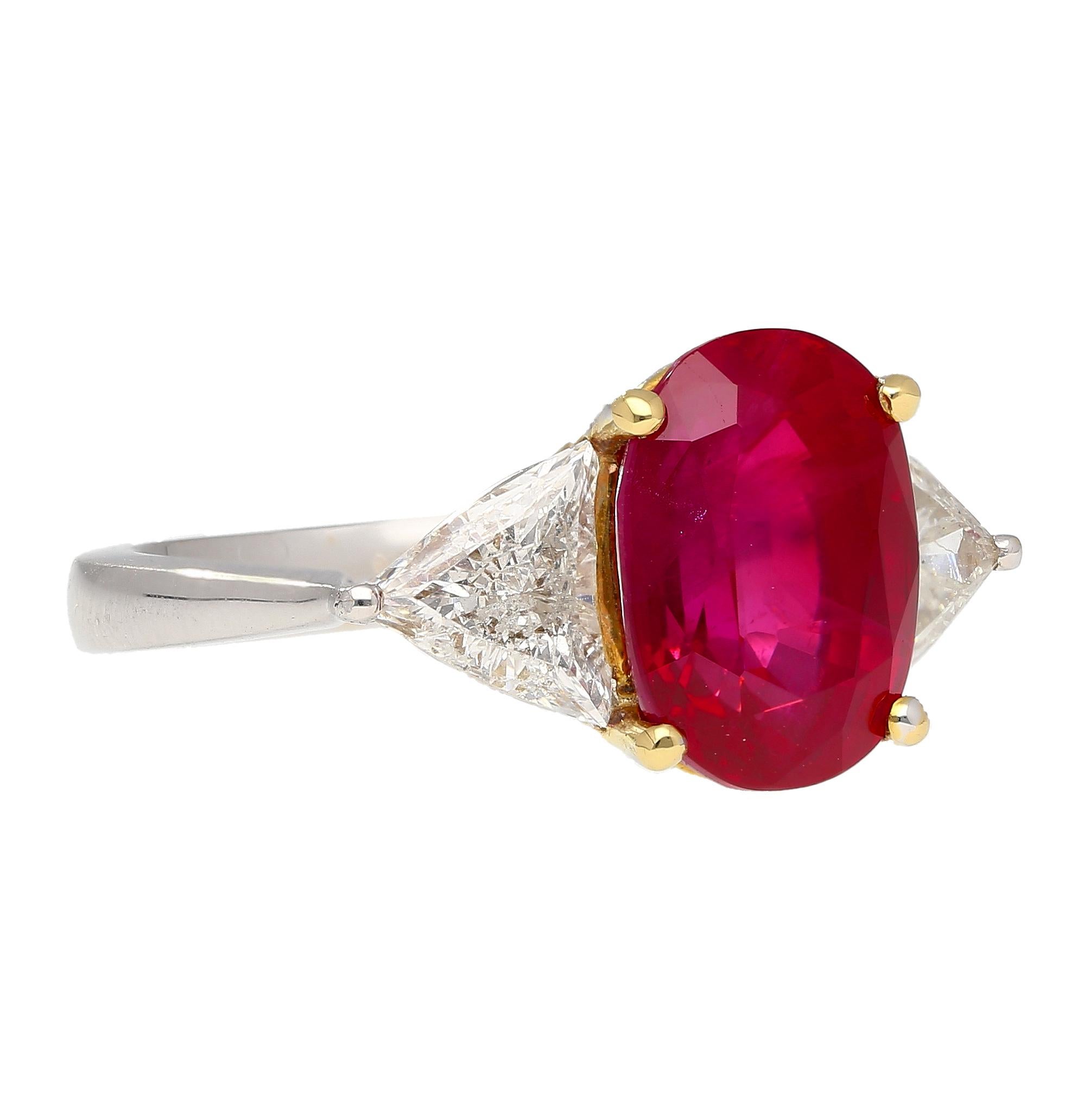 Indulge in sophistication with this ruby and diamond three stone ring ring. Gubelin certified, this natural 4.47 carat oval cut red ruby is accompanied by two triangular shaped diamond side stones of 0.83 CTTW. Set in an 18k white and yellow gold