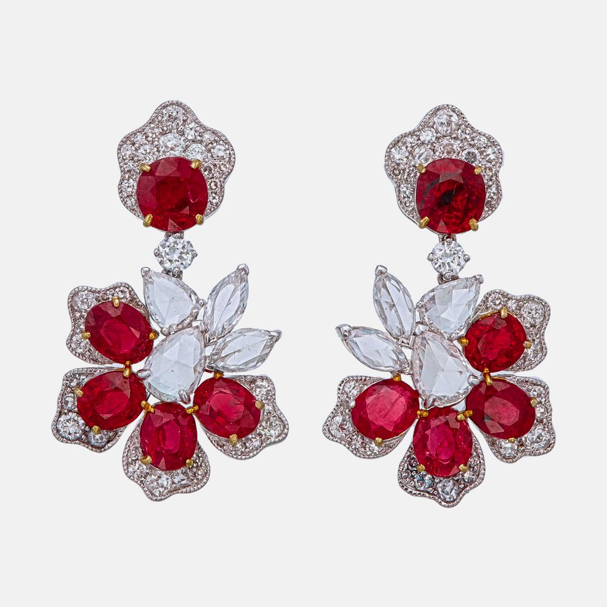 This pair of earrings by Rewa features Burmese rubies with a total weight of 6.51 carats. All rubies are certified by Gübelin Gem Lab as unheated and Burma origin, with a few noted as Pigeon Blood quality. The two center rubies weigh a combined 2.06