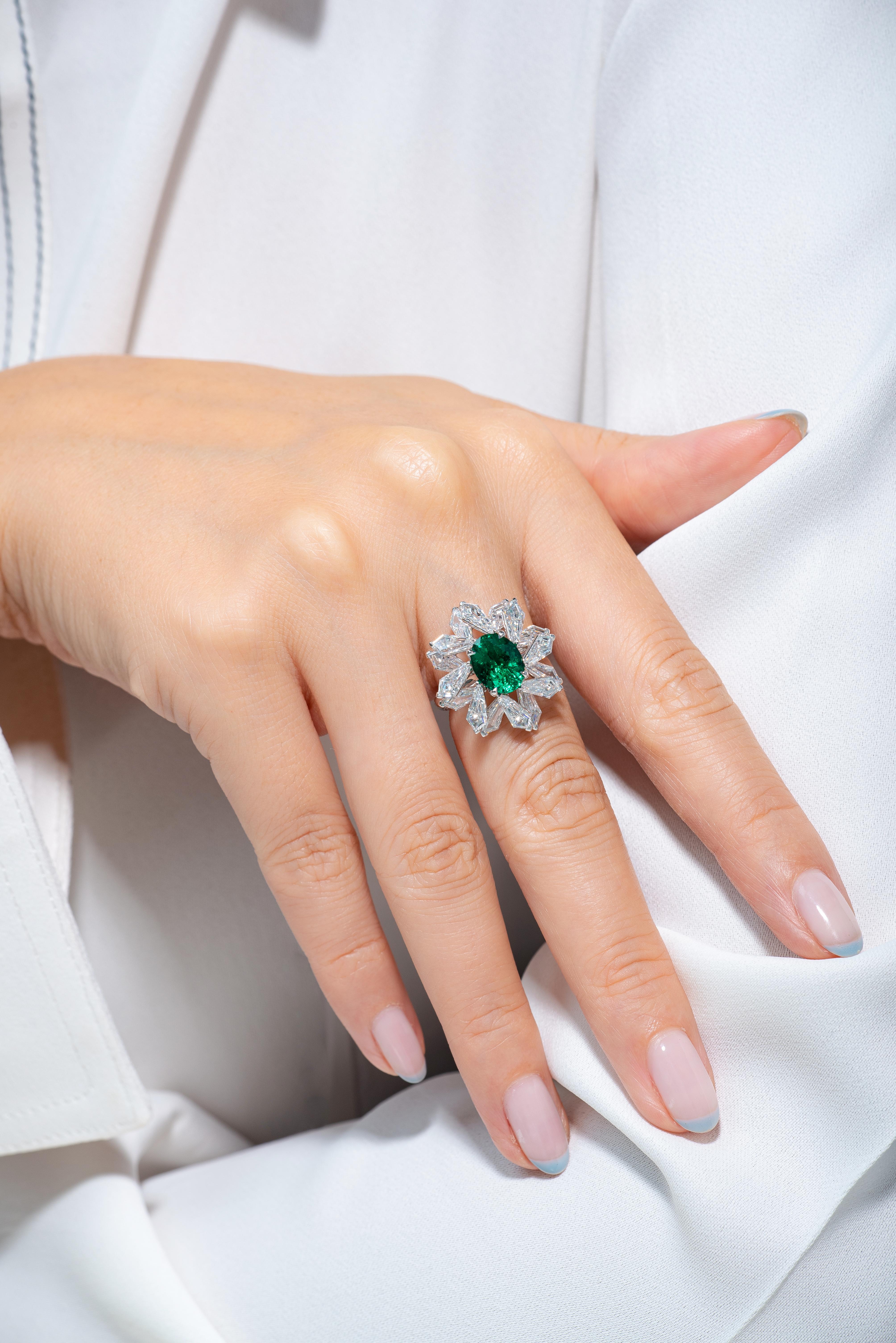 A diamond snowflake ring comprised of 4.62 carats of specialty kite shaped diamonds (D-F color, VS+ clarity). These kite shaped diamonds have been hand cut to surround the oval shaped 2.08 carats Colombian emerald gemstone perfectly. The gemstone is