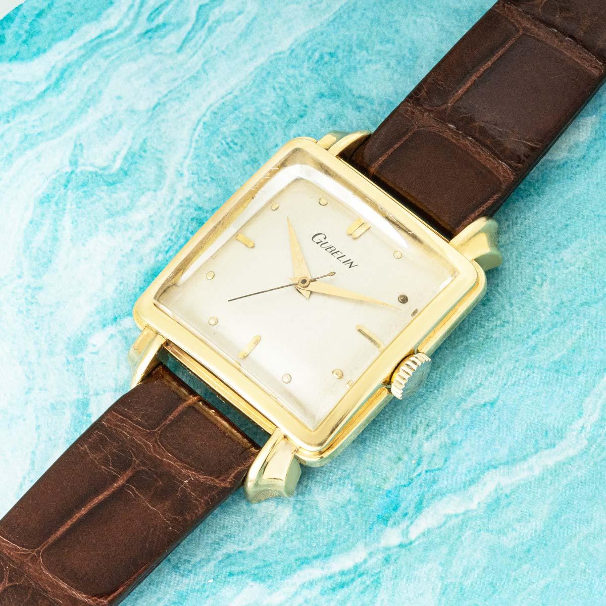 A rare vintage Gübelin Ref. 2029 “Cioccolatone” wristwatch, distinguished by its elegant square cushion-shaped 32mm case with refined fancy lugs.

Powered by a self-winding Bidynator-Patent movement, it features a silver dial with applied hour