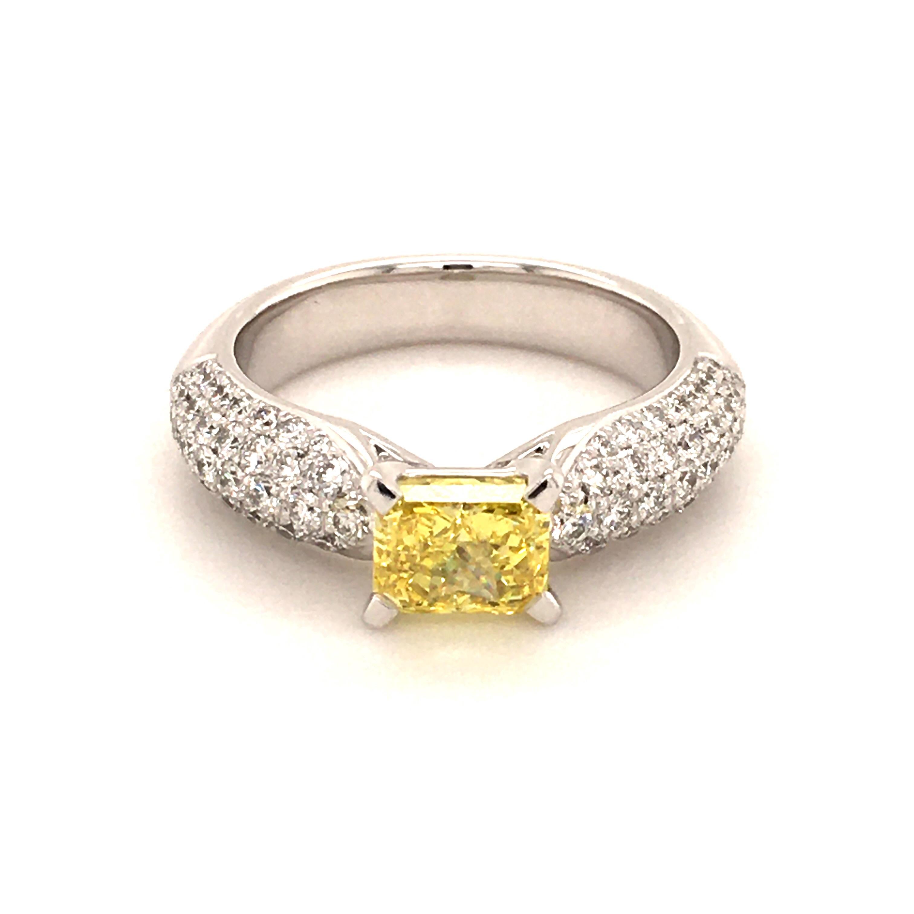 This elegant ring in white gold 750 is created by Gübelin, a famous Swiss jeweller. Its center of attraction is a 1.20 ct fancy vivid yellow radiant cut diamond with a vvs2 clarity. The diamond is GIA certified. It is surrounded by 78 brilliant cut