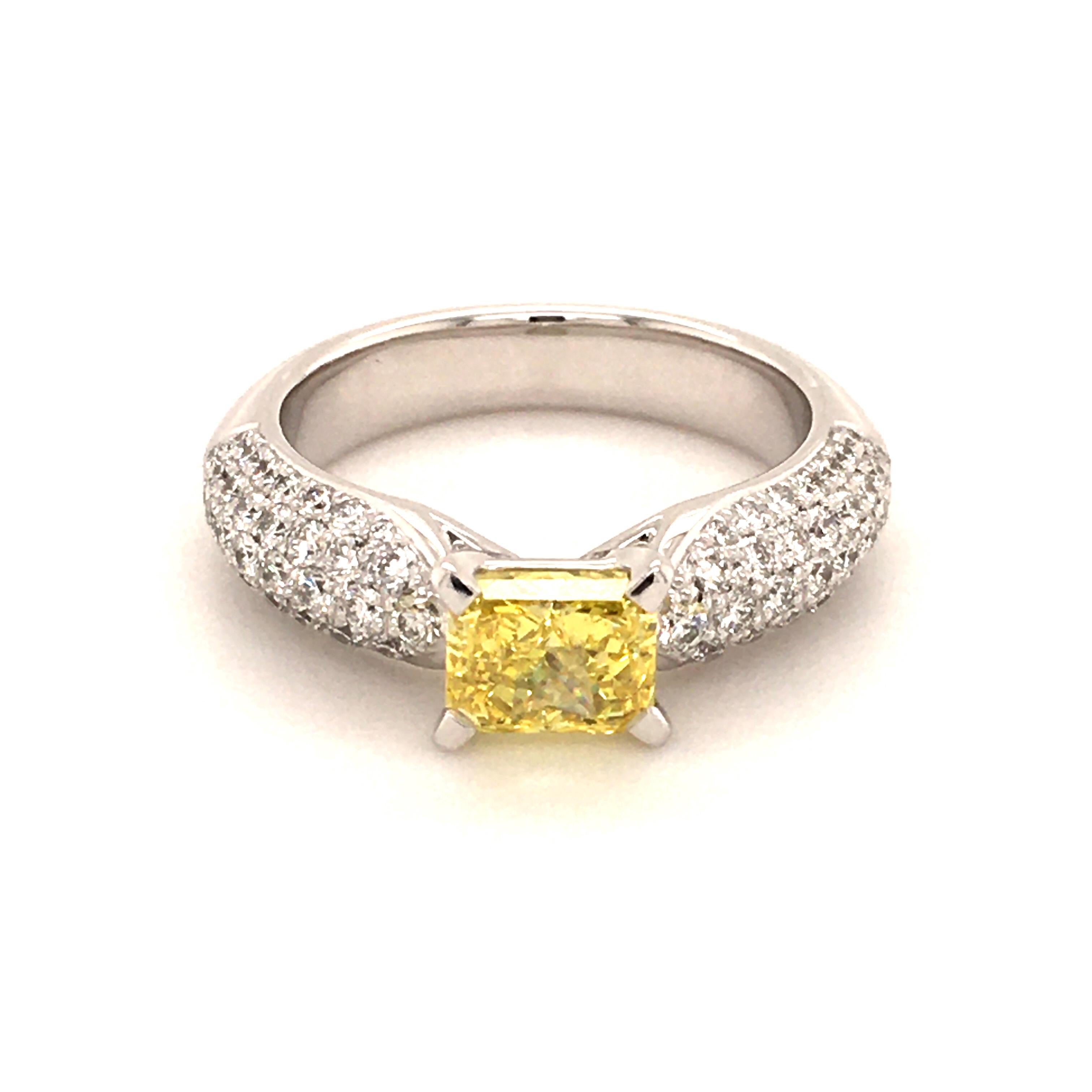 Cette élégante bague en or blanc 750 est créée par Jewell, un célèbre joaillier suisse. Son centre d'attraction est un diamant radiant de 1,20 ct de couleur jaune vif et de pureté vvs2. Le diamant est certifié GIA. Il est entouré de 78 diamants de