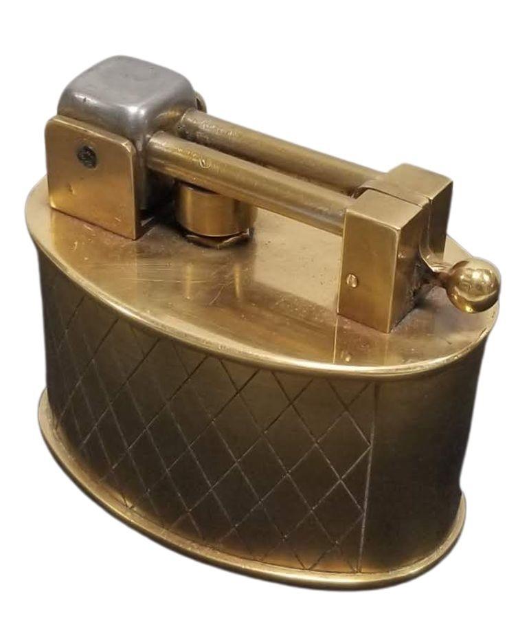 Circa 1950 Made in Switzerland made by Brilux and distributed by Dunhill. Beautifully made brass lighter with spring lift arm flint mechanism where the spring is contained in a shaft with a plunger at the end to push the flint - so the spring never