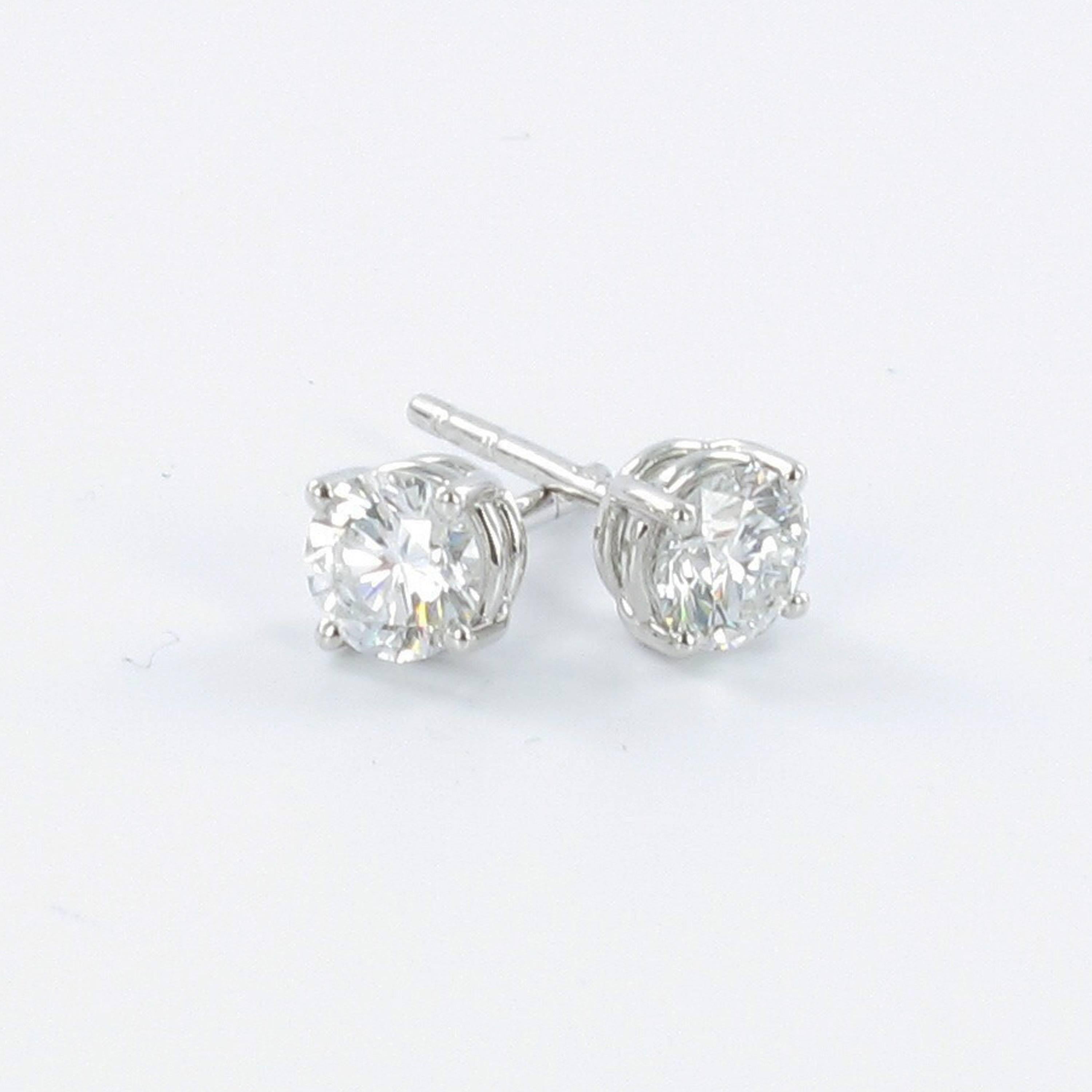 Classic solitaire stud earrings featuring two perfectly matched brilliant cut diamonds of 0.52 and 0.52 carats and of H colour and vs1 clarity. Both diamonds accompagnied by GIA Diamond Dossier. Handmade Gübelin four-prong setting in 18 karat white