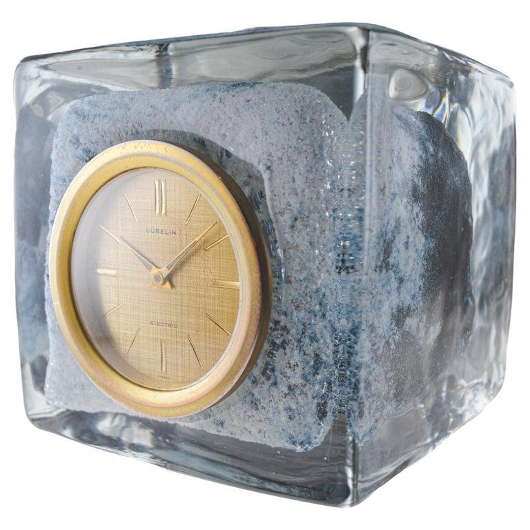 FACTORY / HOUSE: E. Gubelin Watch Company
STYLE / REFERENCE: Table Clock
METAL / MATERIAL: Blown Glass
CIRCA / YEAR: 1950's / 60's
DIMENSIONS: 4.25 Inches Square
MOVEMENT / CALIBER: Battery Operated
DIAL / HANDS: Original Gilt Linen with Gilt Hands