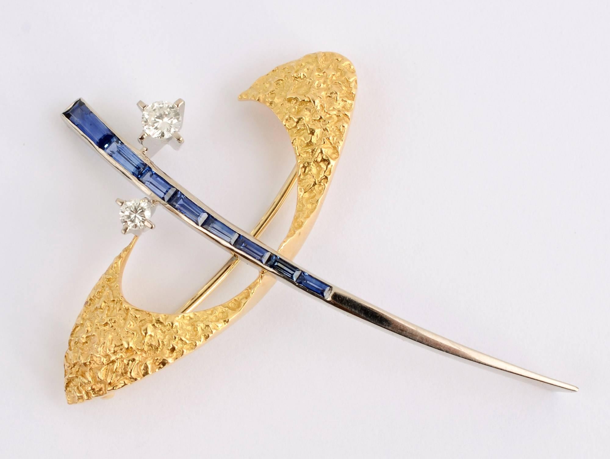 Wonderfully airy, abstract brooch by Swiss designer, Gubelin . Sapphires and diamonds are set in white gold with finely textured areas of yellow gold. The brooch measures 2 1/16 inches in length and 1 5/8 inches in width.