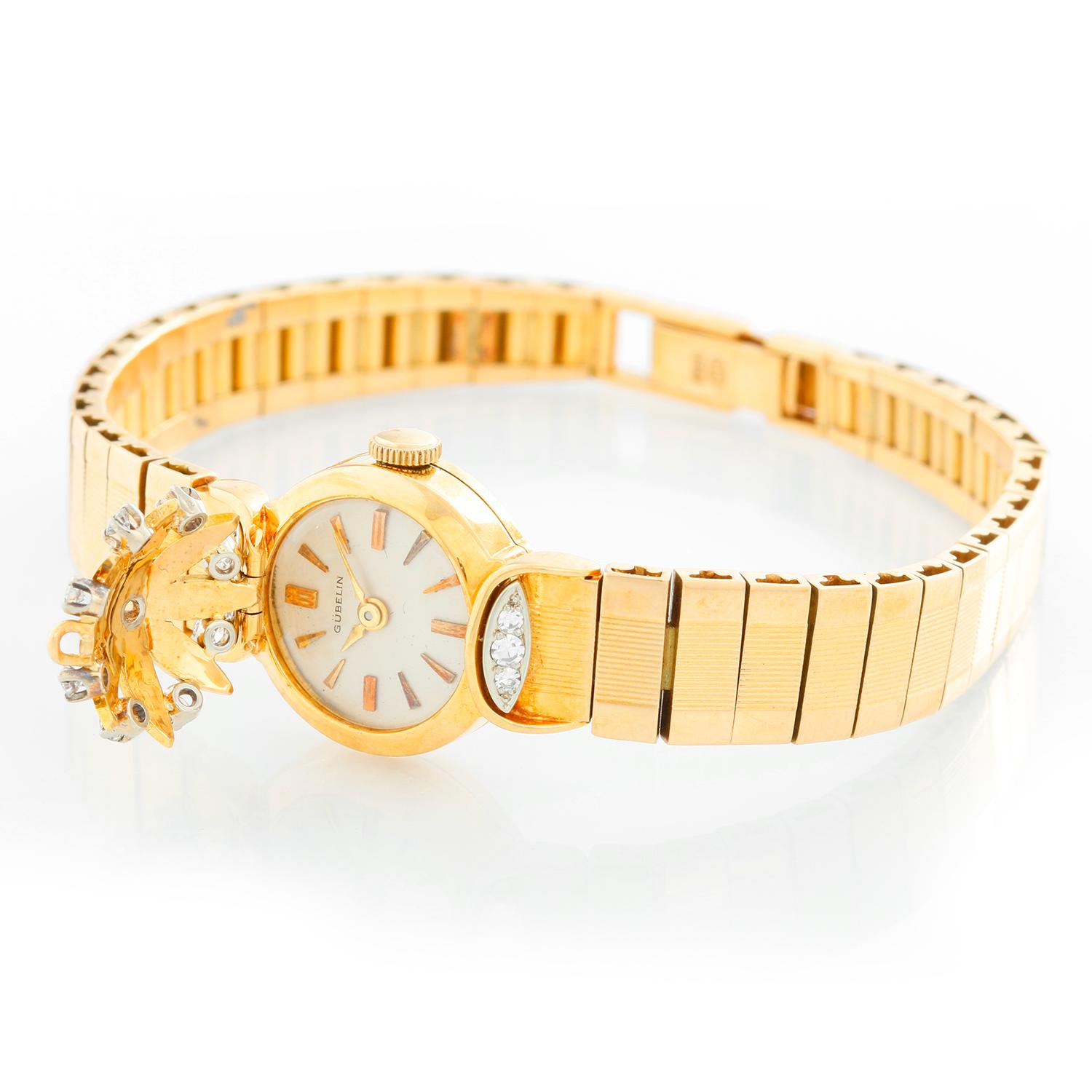 Gubelin lady's 18k yellow gold and diamond bracelet watch with concealed dial and manual-wind movement. 18k yellow gold case with flower-petal-shaped cover over dial. Silvered dial with gild markers. 18k yellow gold bracelet (will fit 6-3/4-in.