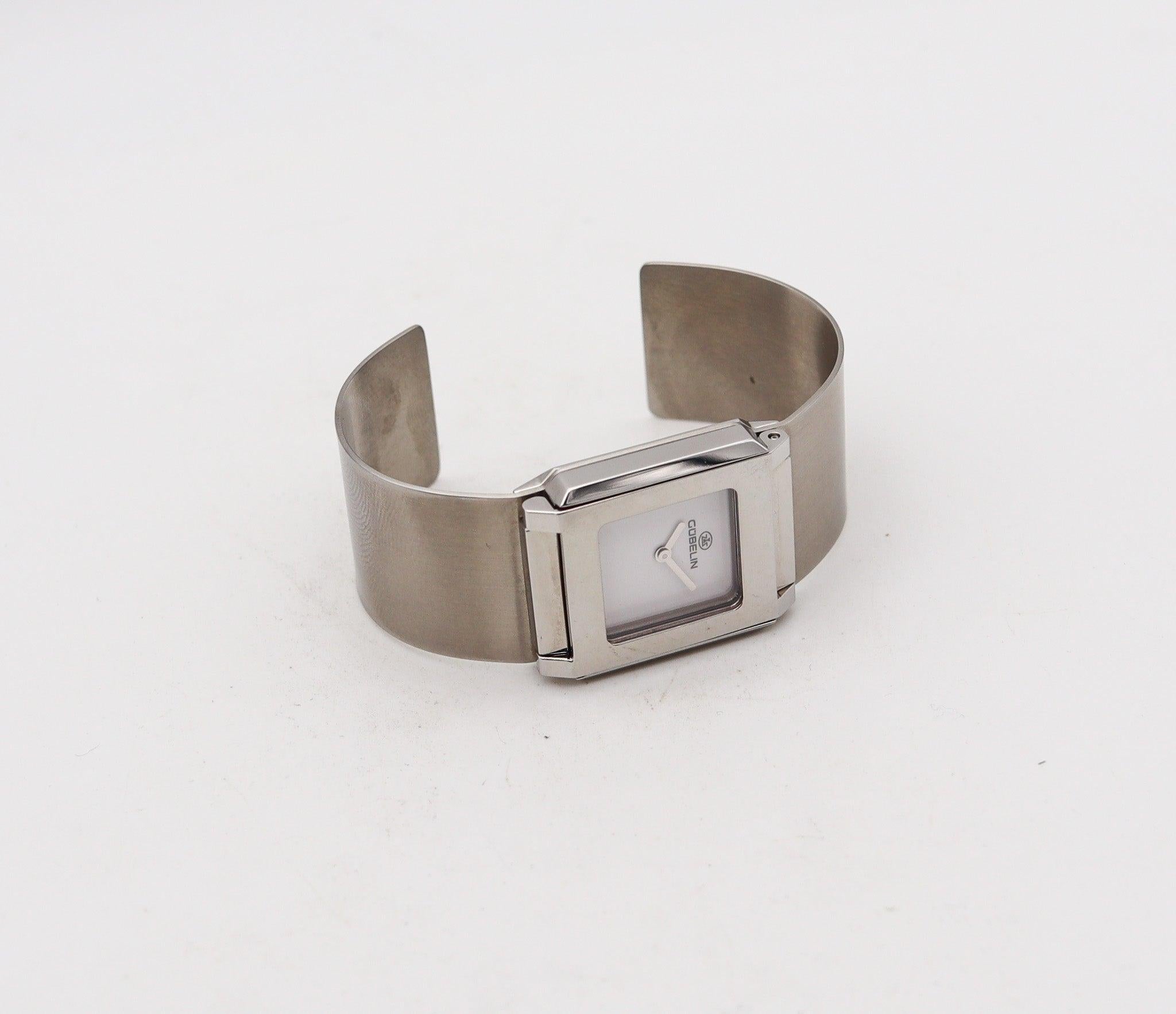 Montre-bracelet Techno cuff conçue par Gubelin.

Belle montre-bracelet manchette très moderniste, créée à Genève en Suisse par la maison de joaillerie Gubelin. Il s'agit du modèle Techno taille C, conçu comme une manchette flexible semi-rigide en