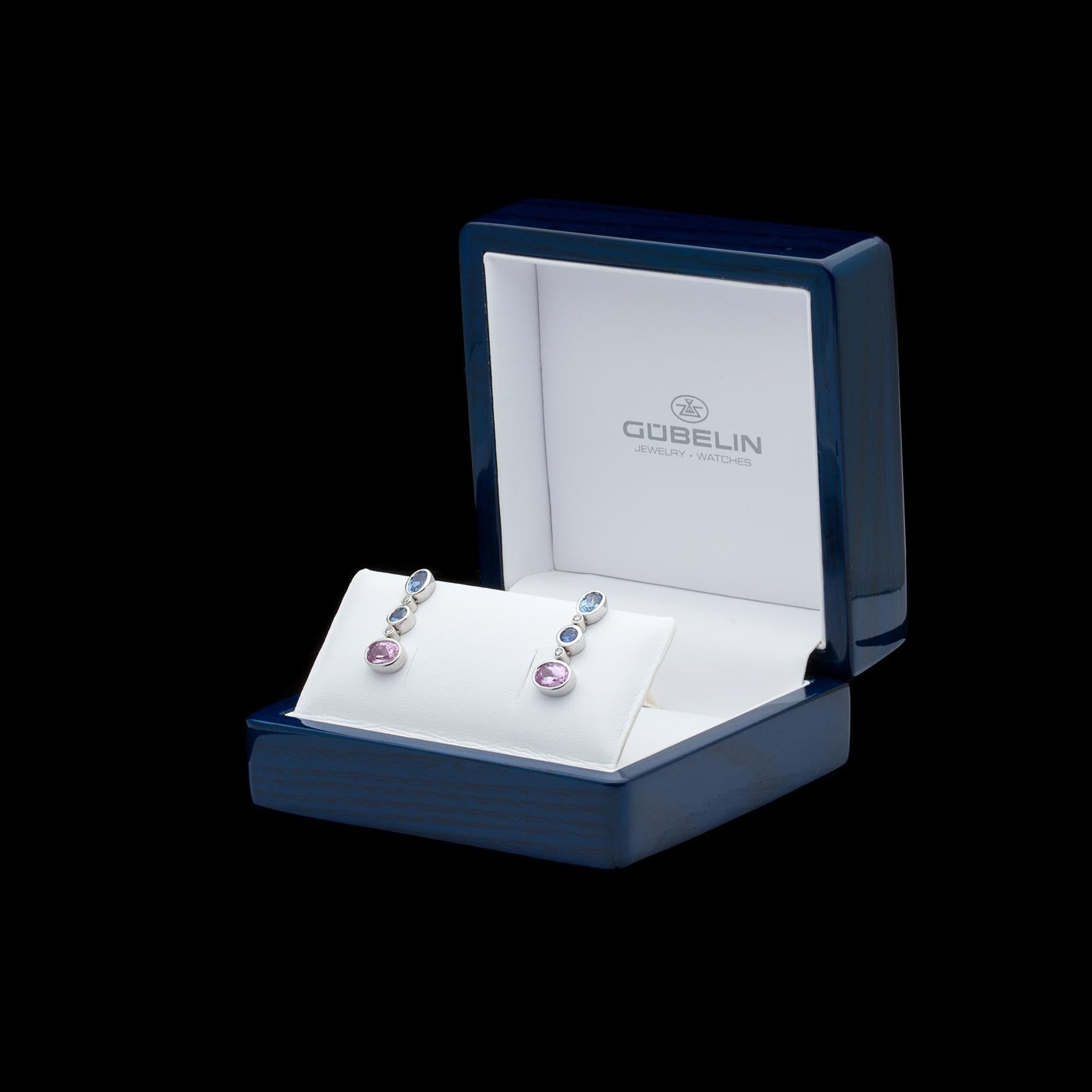 By Swiss designer Gubelin, the 18k white gold earrings feature 6 bezel-set pink and blue sapphires, both oval and round-cut, set between with 4 bezel-set round brilliant-cut diamonds. With a total sapphire weight of 4.33 carats, and diamonds