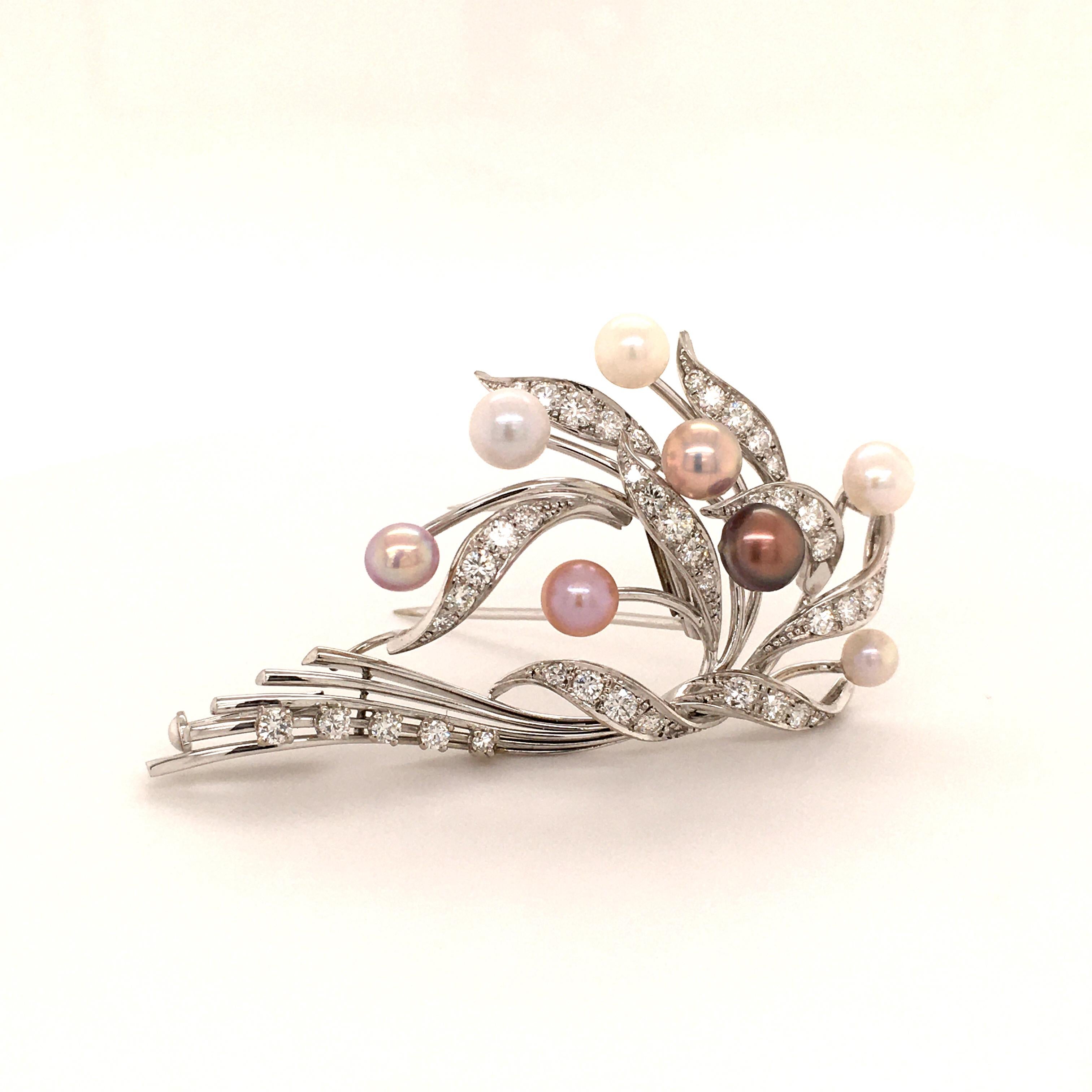 This elegant brooch features eight natural pearls with colors ranging from white to light pink and purple. Mounting in 18 karat white gold, set with 43 brilliant cut diamonds of F/G color and vs clarity, total weight 1.25 carats.
Excellent