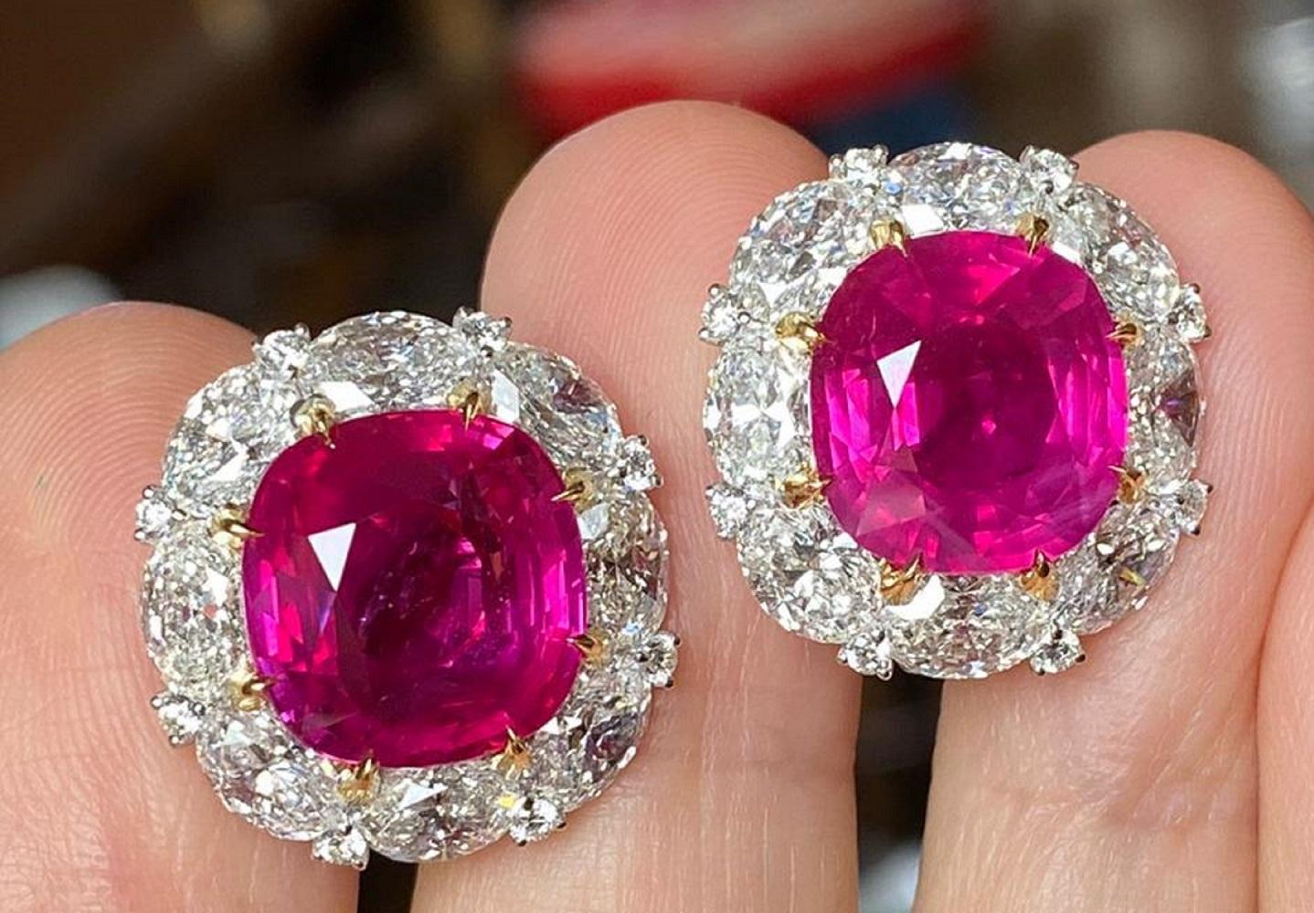 An impressive and rare pair of earrings each set with a large round shape rubies from Burma (Myanmar)  and round brilliant-cut diamond setting. 

The total weight of the two burma is in excess of 14 carats, certified by GUBELIN with no gemological