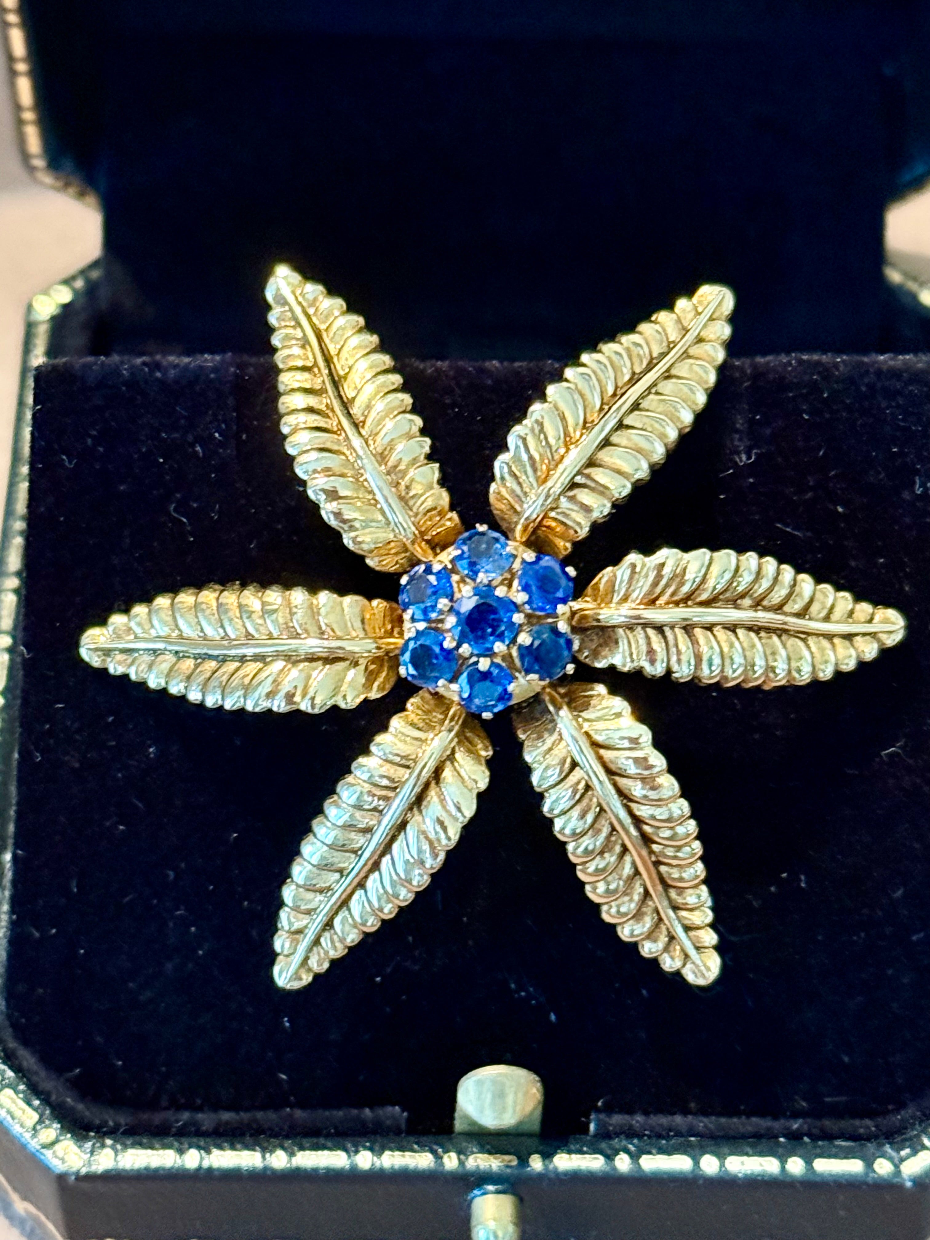 Adorn yourself with the timeless elegance of this Gübelin Lucerne , Switzerland 18 K yellow Gold stylized flower brooch. Expertly crafted, this exquisite piece features a delicate flower design, the brooch is adorned with 7 captivating natural