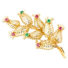 GUBELIN - Broche feuille en or jaune, rubis et émeraudes