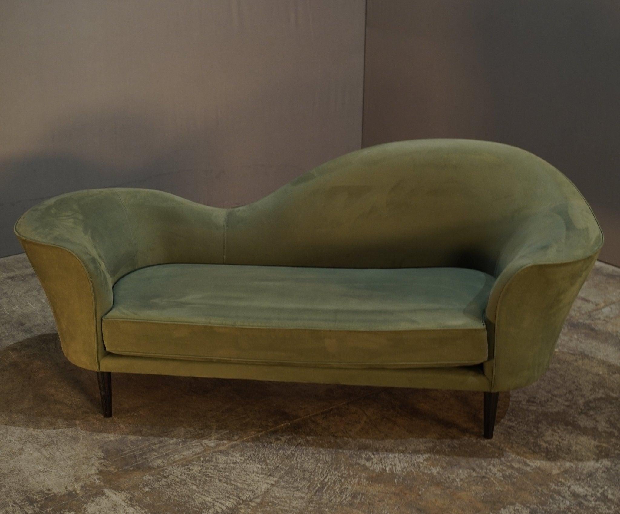 The Gubi Olsen Grand Piano Green Velvet Sofa is a striking fusion of mid-century charm and modern luxury. Designed by Gubi Olsen, its iconic curved shape mimics the fluid lines of a grand piano, making it both a functional piece and a statement of