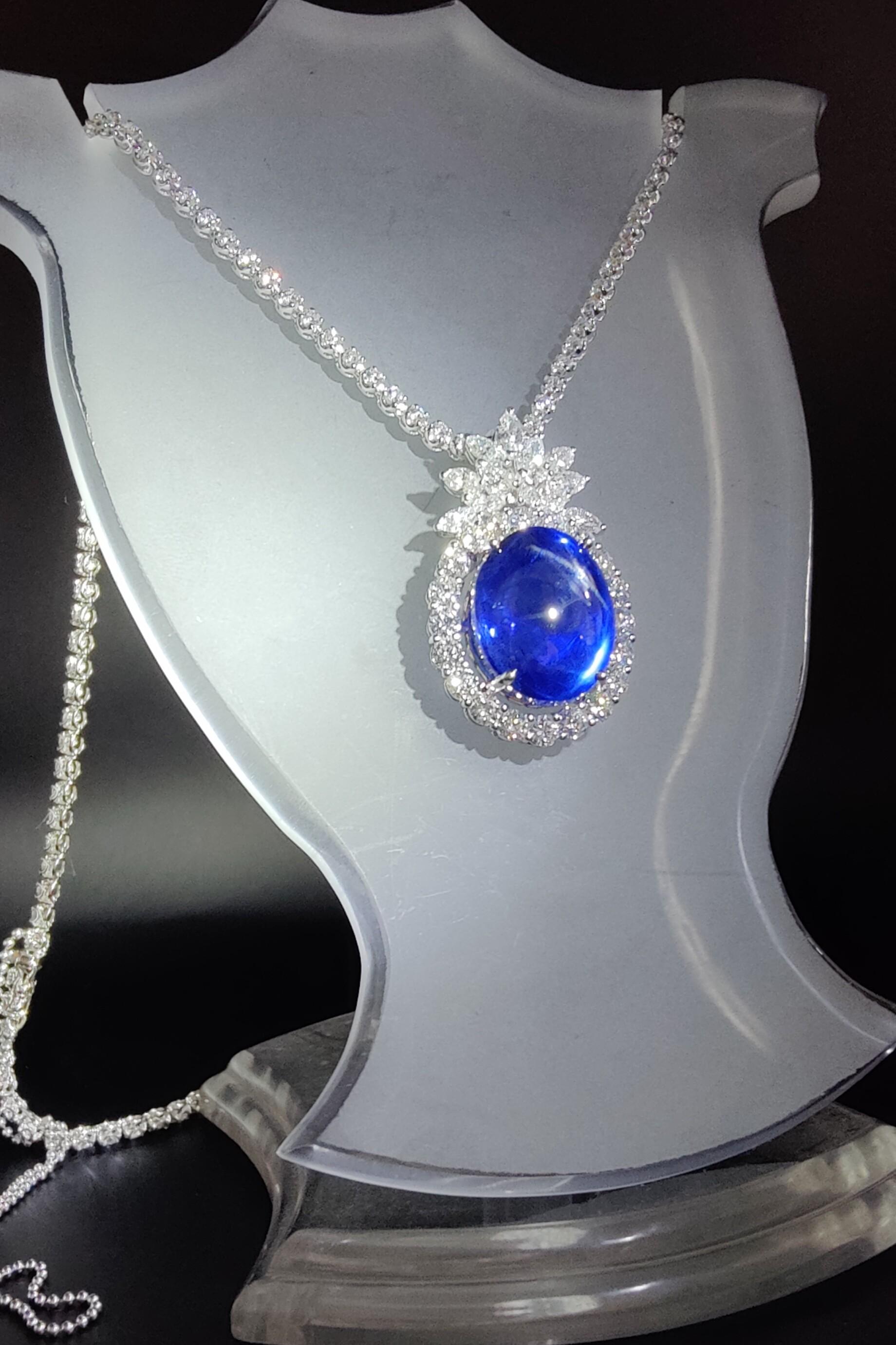 This timeless elegant Blue Star Sapphire Diamond Pendant Necklace will never go out of style!

Transparent with minimal impurities, the stunning centerpiece 26.88-carat oval cabochon cut star sapphire radiates a saturated royal blue color. With the