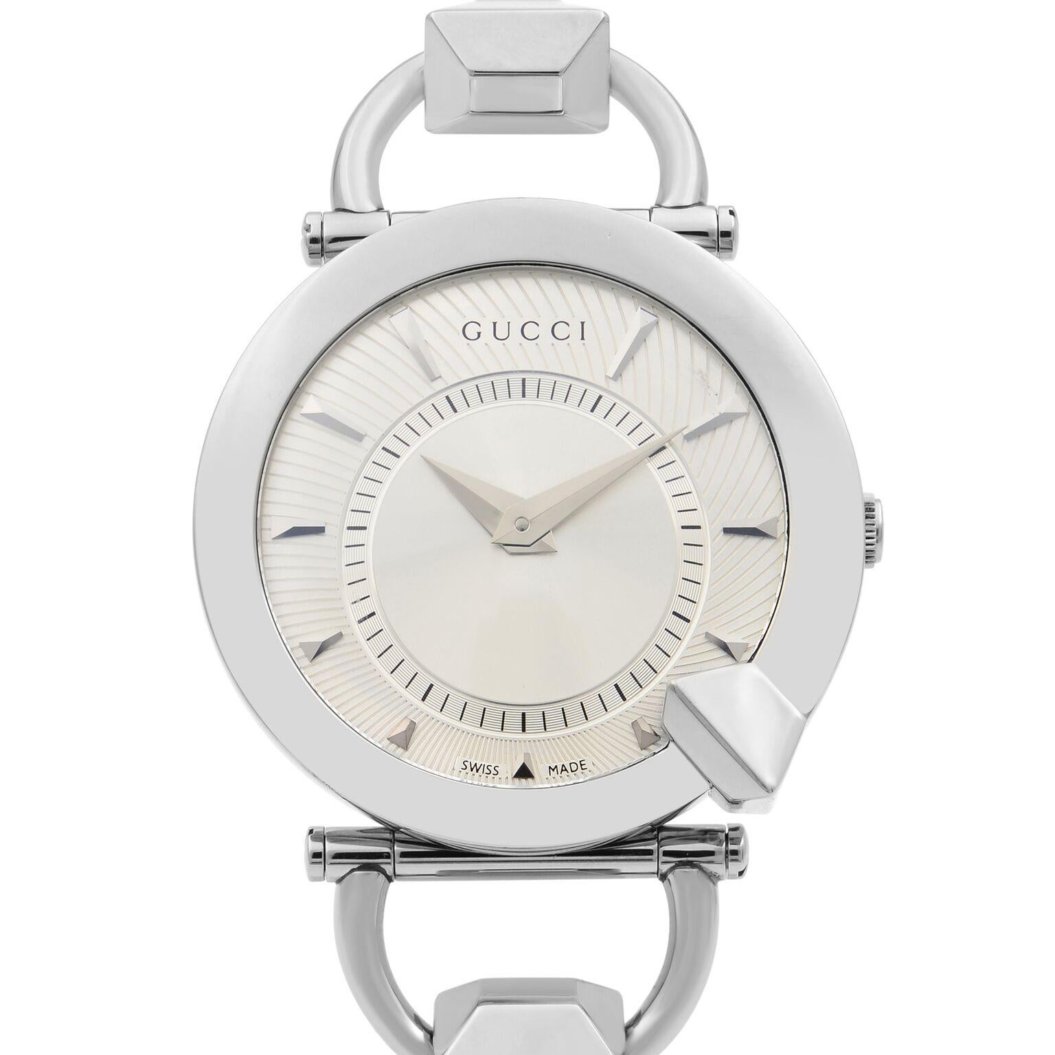 This New Without Tags Gucci Chiodo YA122508 is a beautiful Ladie's timepiece that is powered by quartz (battery) movement which is cased in a stainless steel case. It has a round shape face,  dial and has hand sticks style markers. It is completed