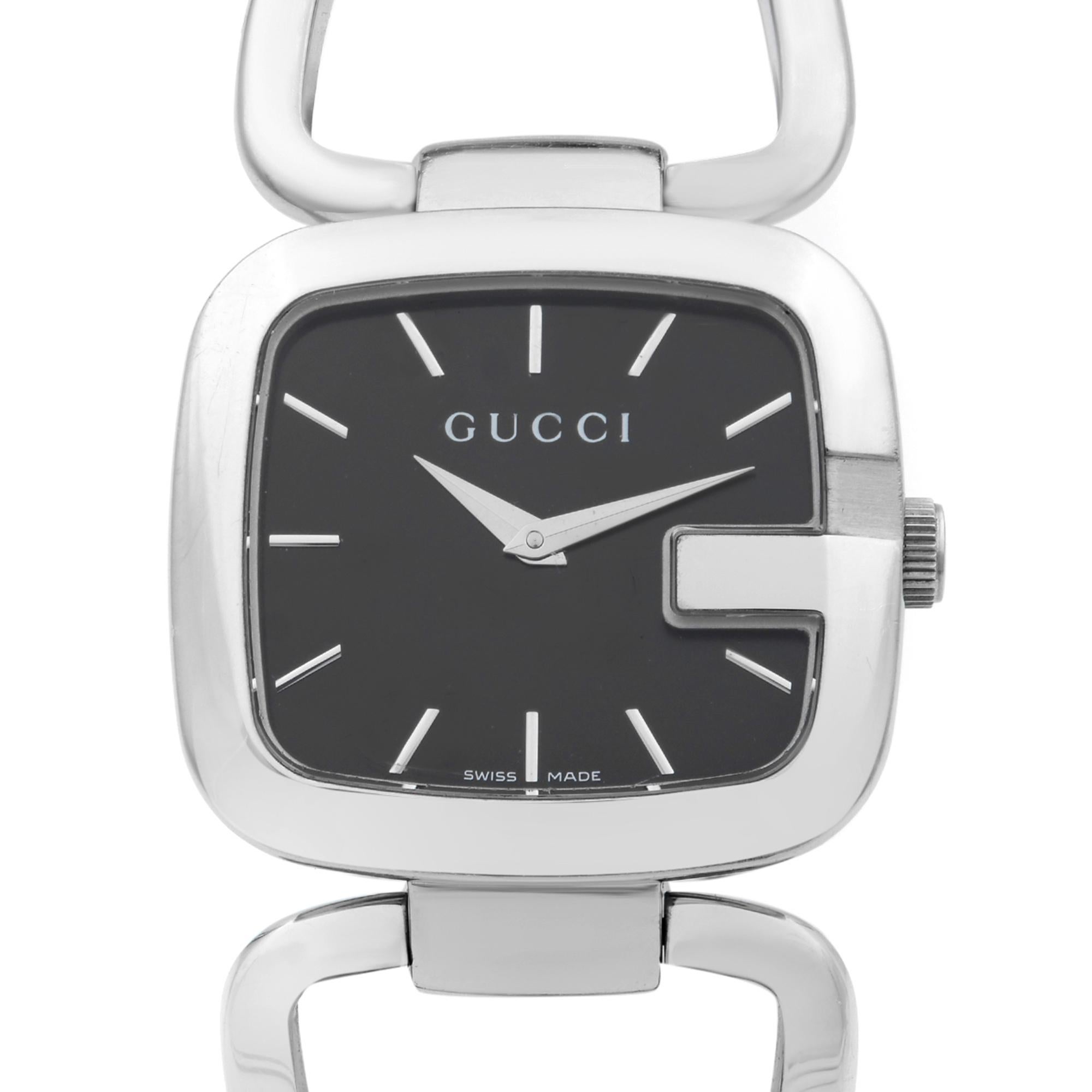 This pre-owned Gucci 125 YA125407 is a beautiful Ladie's timepiece that is powered by quartz (battery) movement which is cased in a stainless steel case. It has a  rectangle shape face,  dial and has hand sticks style markers. It is completed with a