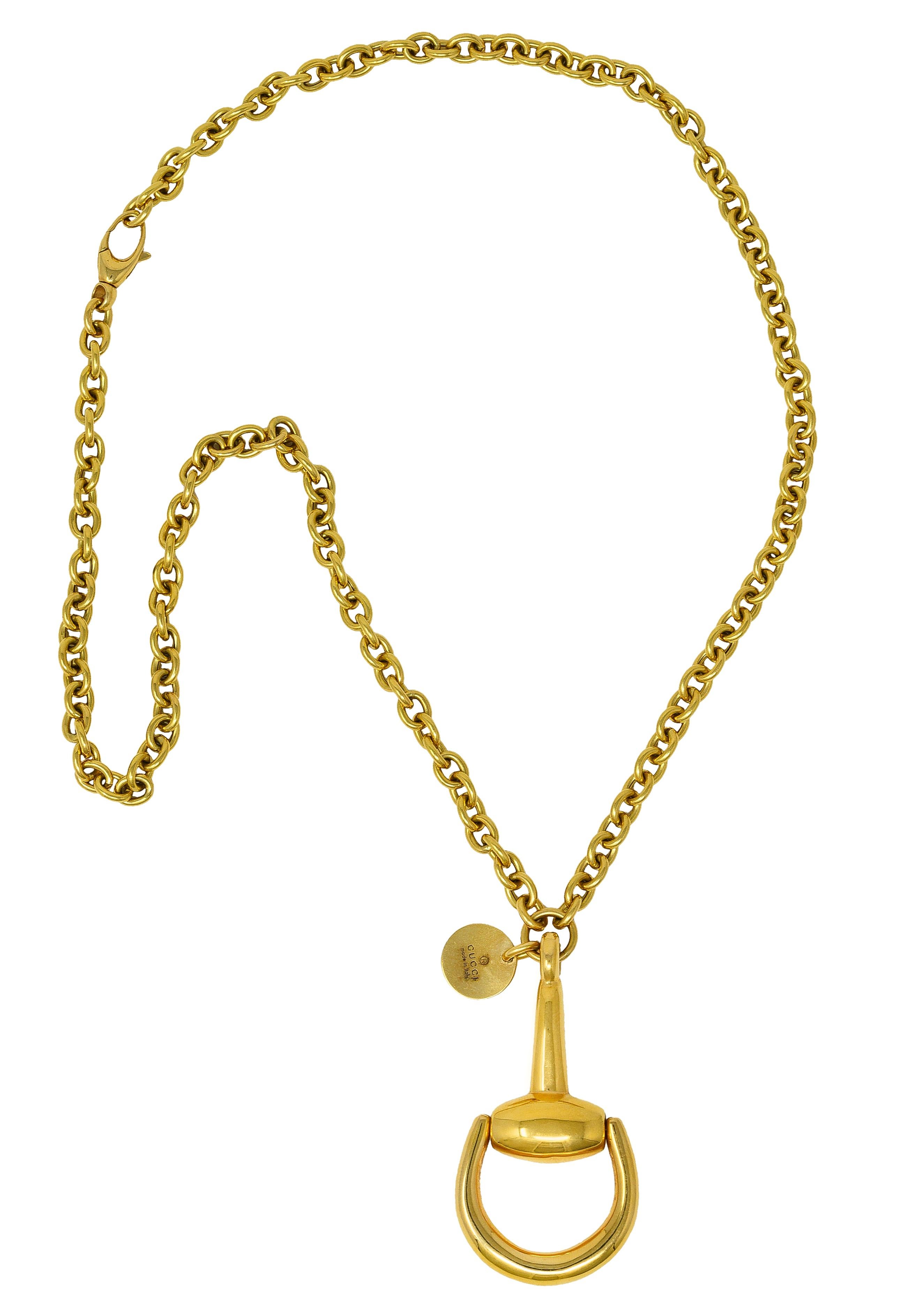 Necklace is designed as cable chain suspending a substantial horsebit motif pendant. High polish with articulating looped bit. Stamped 750 with Italian assay marks for 18 karat gold. With logo tag fully signed Gucci, Made in Italy. Circa: 1990's,