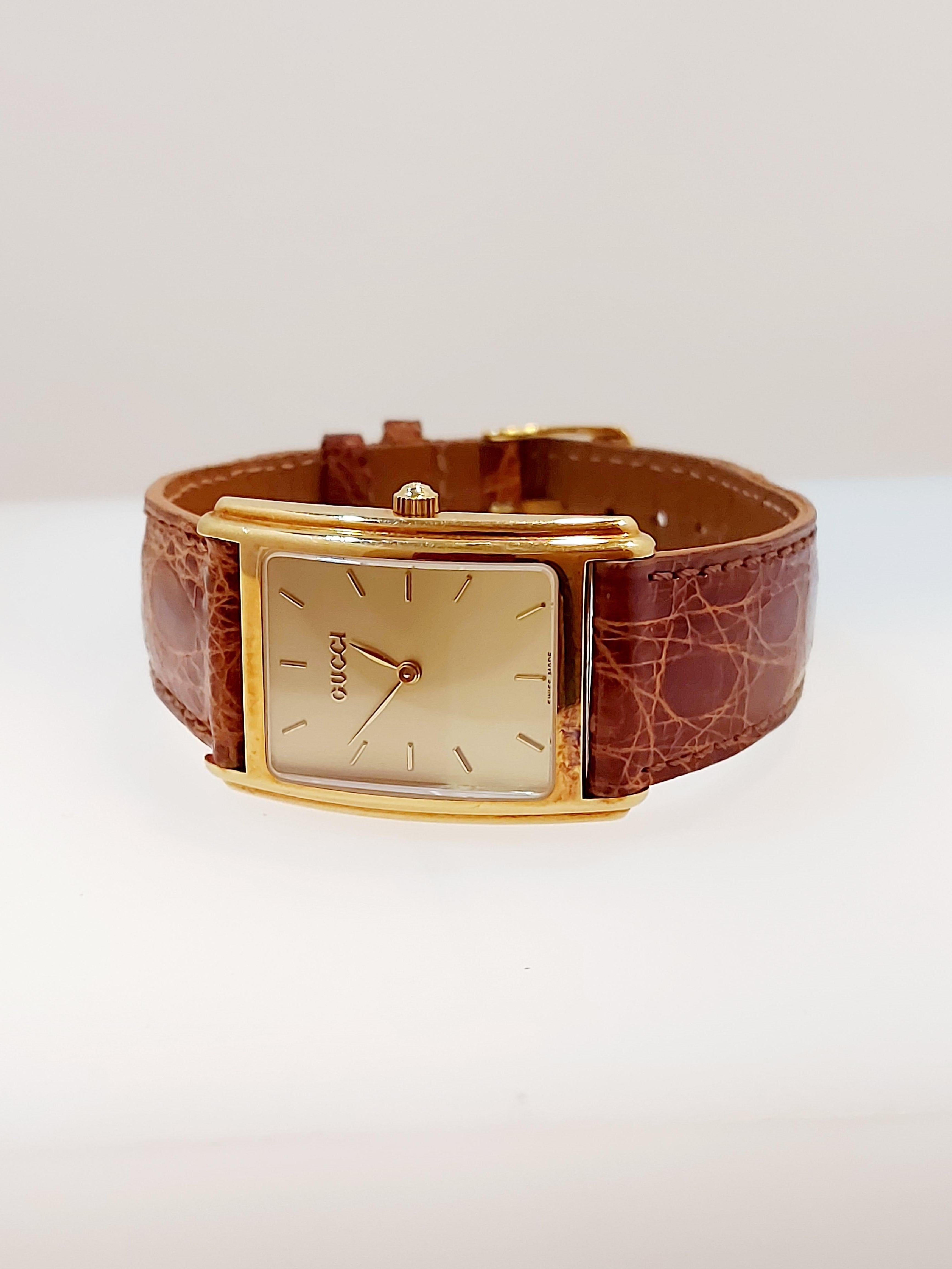 Rectangular Gucci quartz watch 18ct yellow gold on original Gucci brown leather strap with batons on a champagne dial, model number 715 M serial number 0002368.