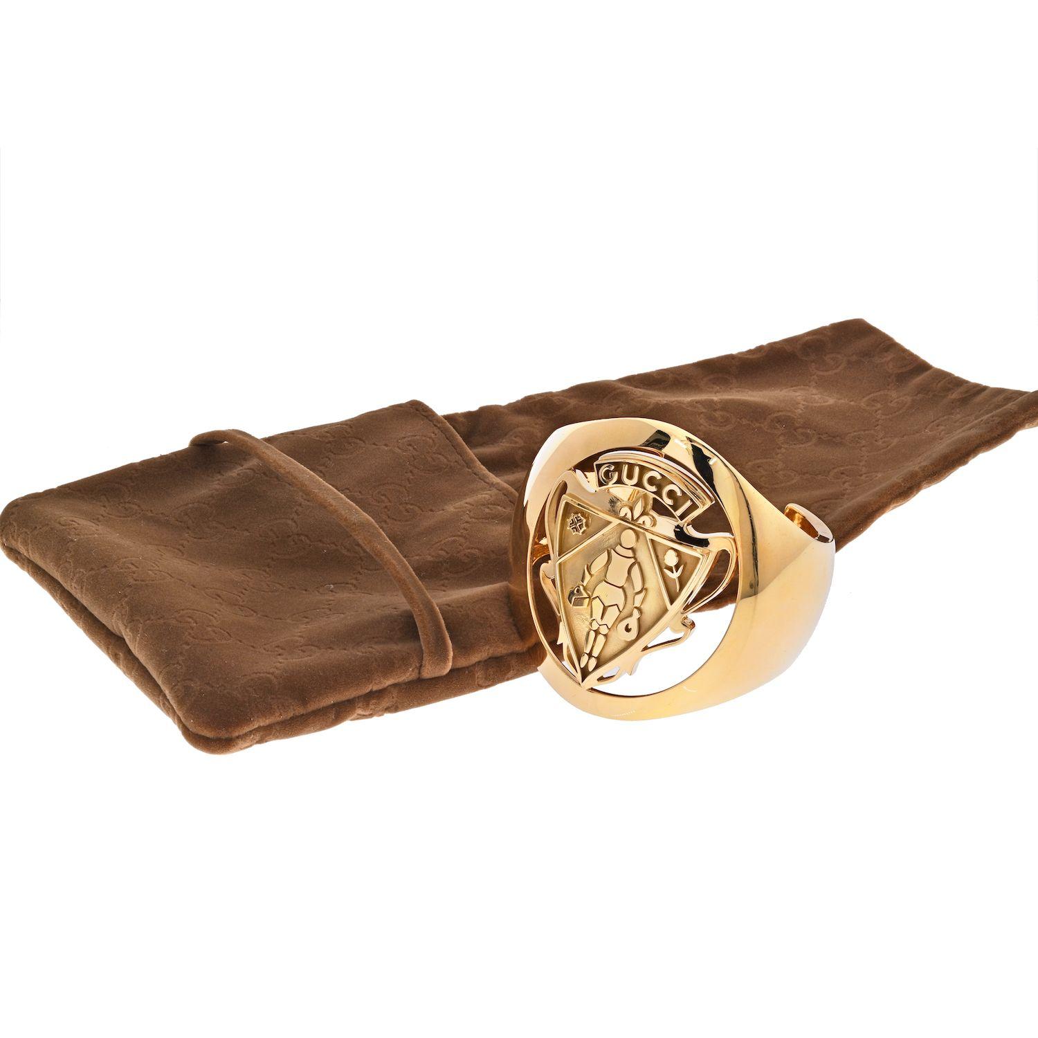 Solid 18K Yellow gold cuff bangle by Gucci. This is a rare Coat Of Arms Heritage collection item with exquisite relief detail as seen in the pictures. This bracelet features a knight in armor holding Leather Goods Luggage and Purse as part of the