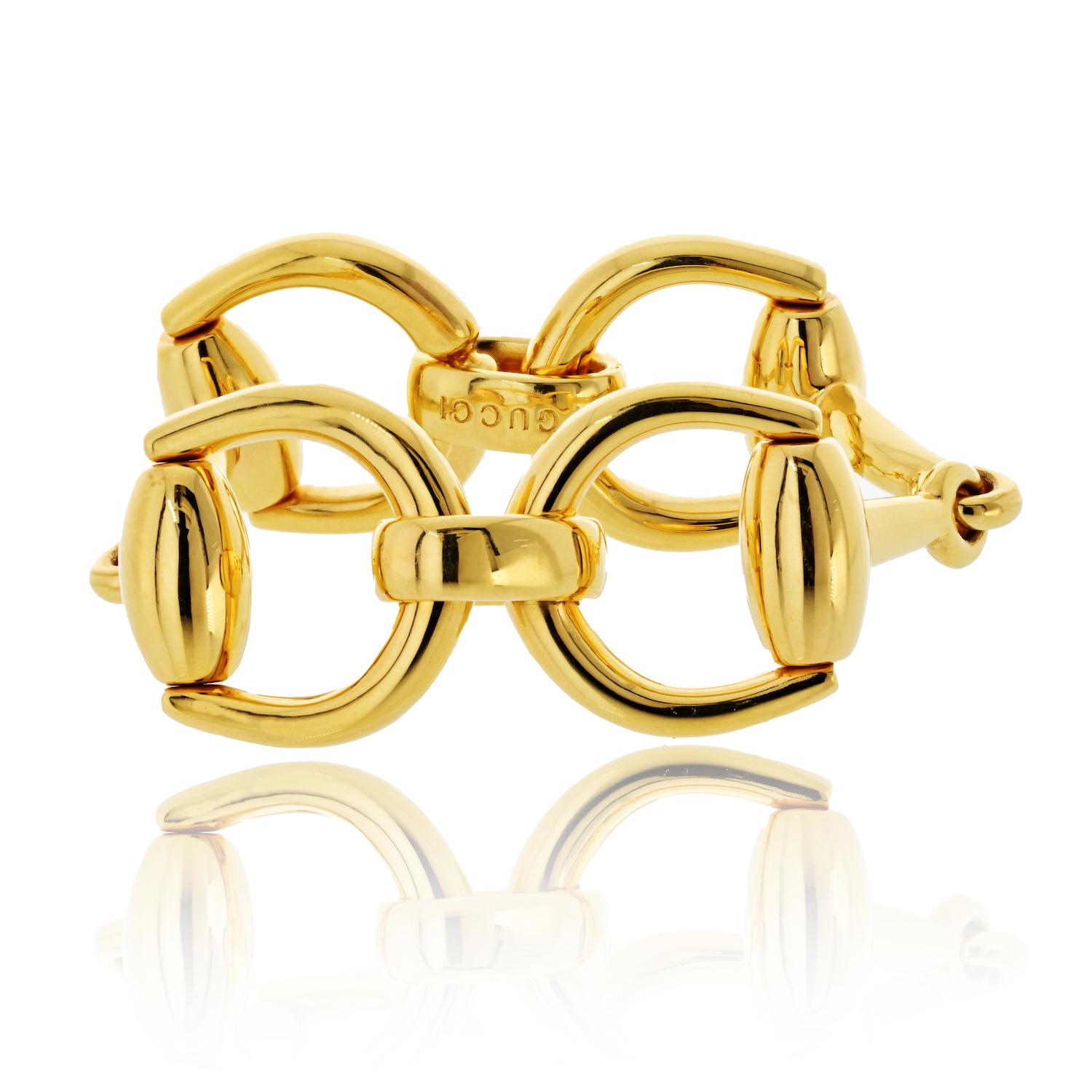 A bold and iconic statement piece from Gucci, crafted in luxurious 18K yellow gold. This vintage 8-inch bracelet showcases four oversized interlocking horsebit links—a signature design inspired by Gucci’s equestrian heritage. Weighing 60 grams, its