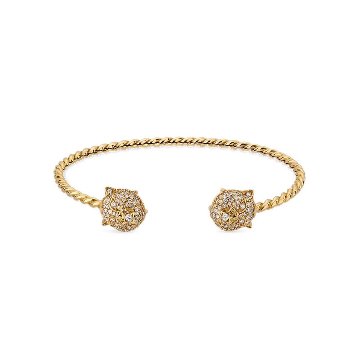 This piece gives you the best of both worlds. Handcrafted from 18K yellow gold both ends of this Gucci bracelet features their timeless Le Marché des Merveilles feline head covered in precious diamonds. You can instantly achieve a different look by