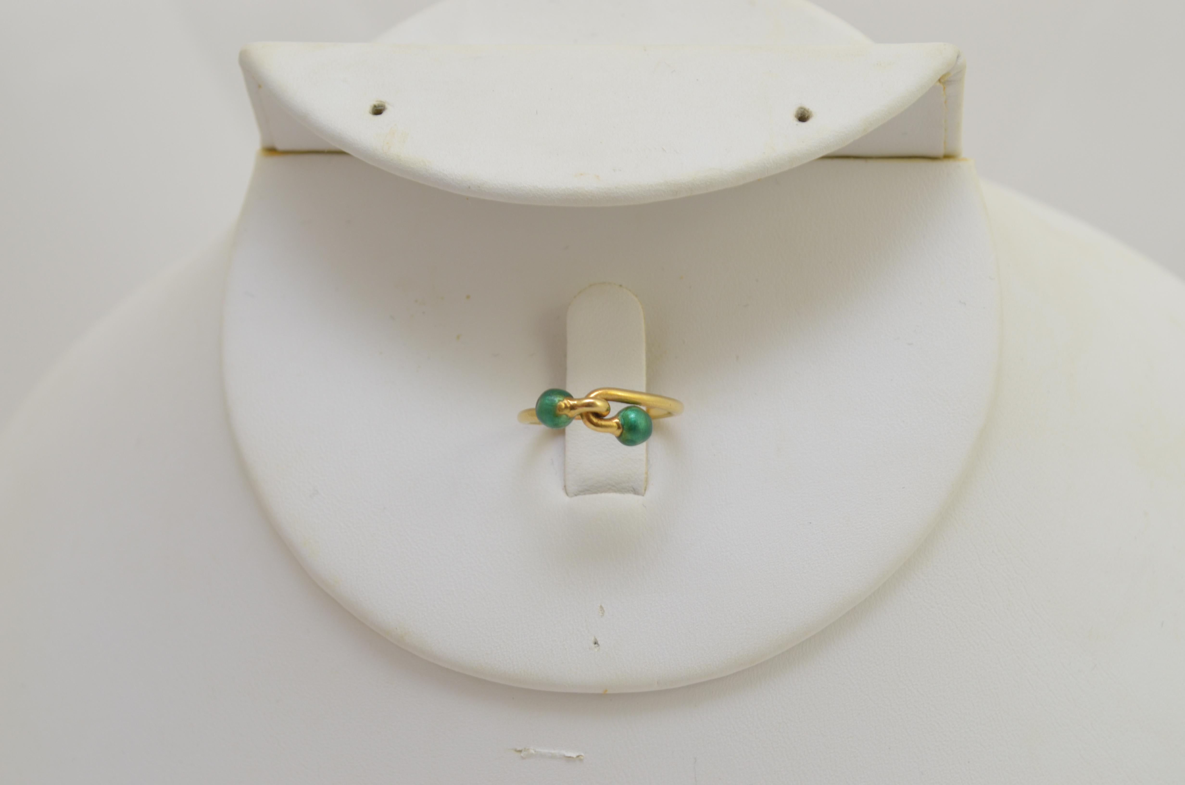 Gucci Ring in 18k Gelb mit einem Knotenmuster mit grünen Kugelspitzen. Der Ring hat die Größe 4,5, hergestellt in Italien.