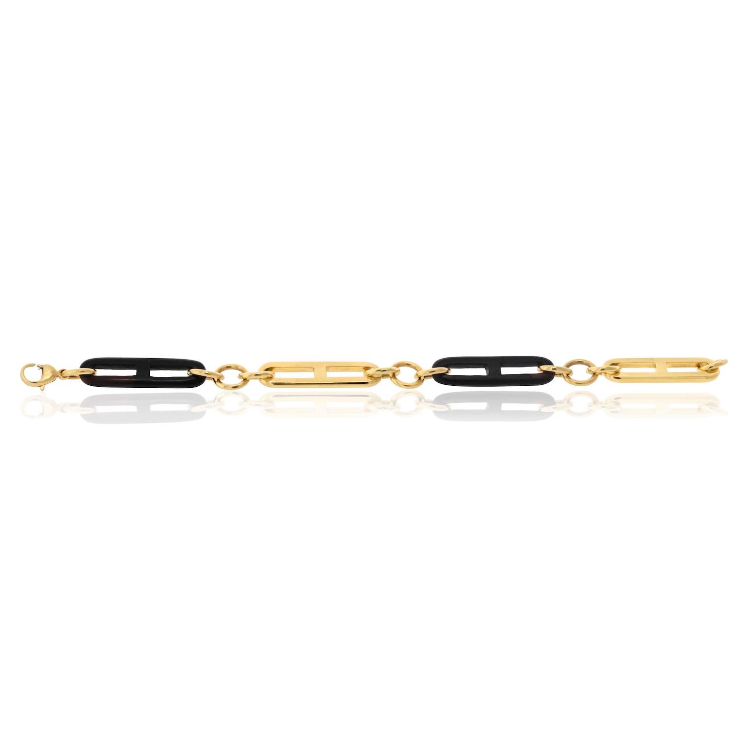 Questo bracciale a maglie di Gucci è un vero e proprio pezzo forte, perfetto per chi apprezza l'alta gioielleria con un tocco moderno. La combinazione di oro e legno lo rende un accessorio versatile, adatto sia alle occasioni casual che a quelle