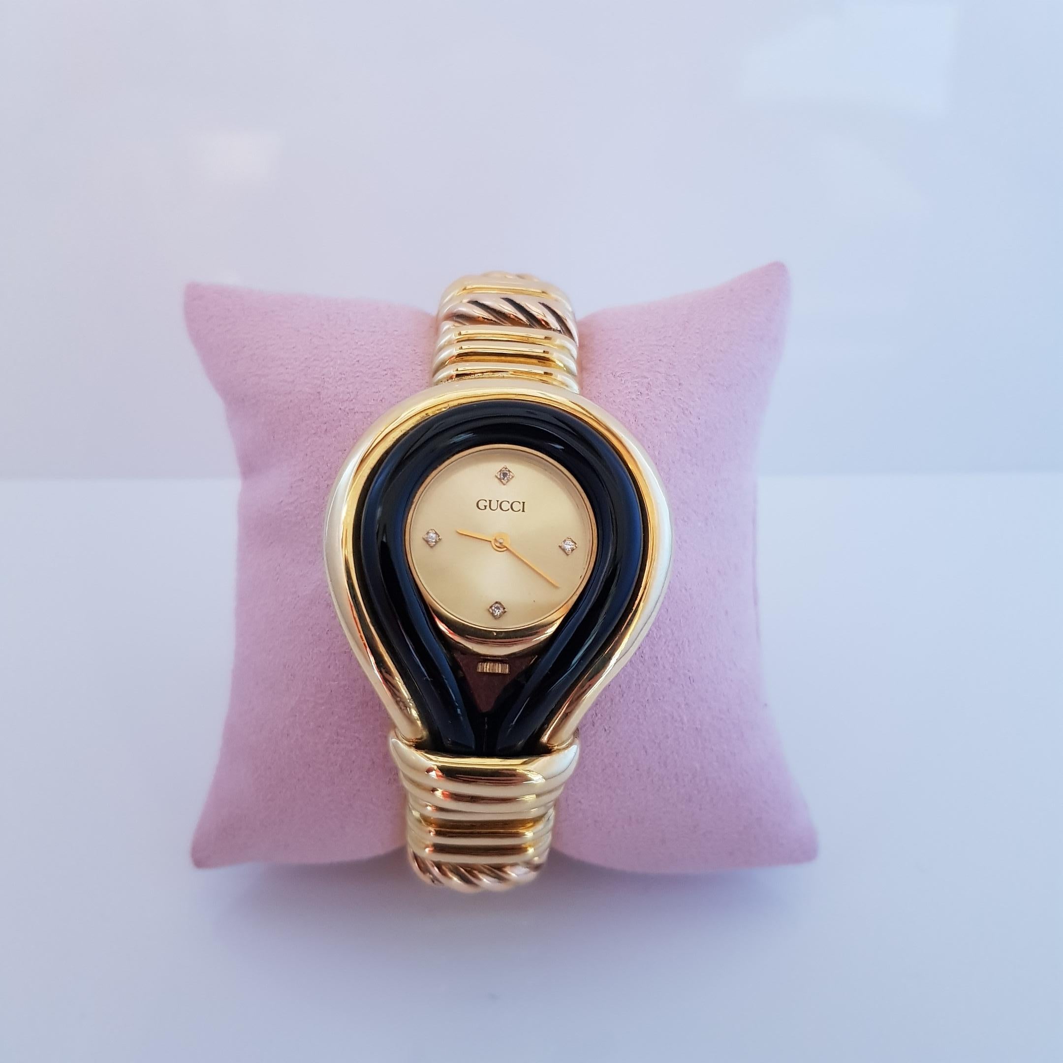 Gucci Quartz Watch. The case is set in 18KT Yellow with onyx bezel, the bracelet is made in 18kt Yellow and Rose 
 gold and it has buckle closure. The dial satiné soleil it has carats 0,03 diamond indexes. Cca 1970 it has Paolo Gucci Original Design