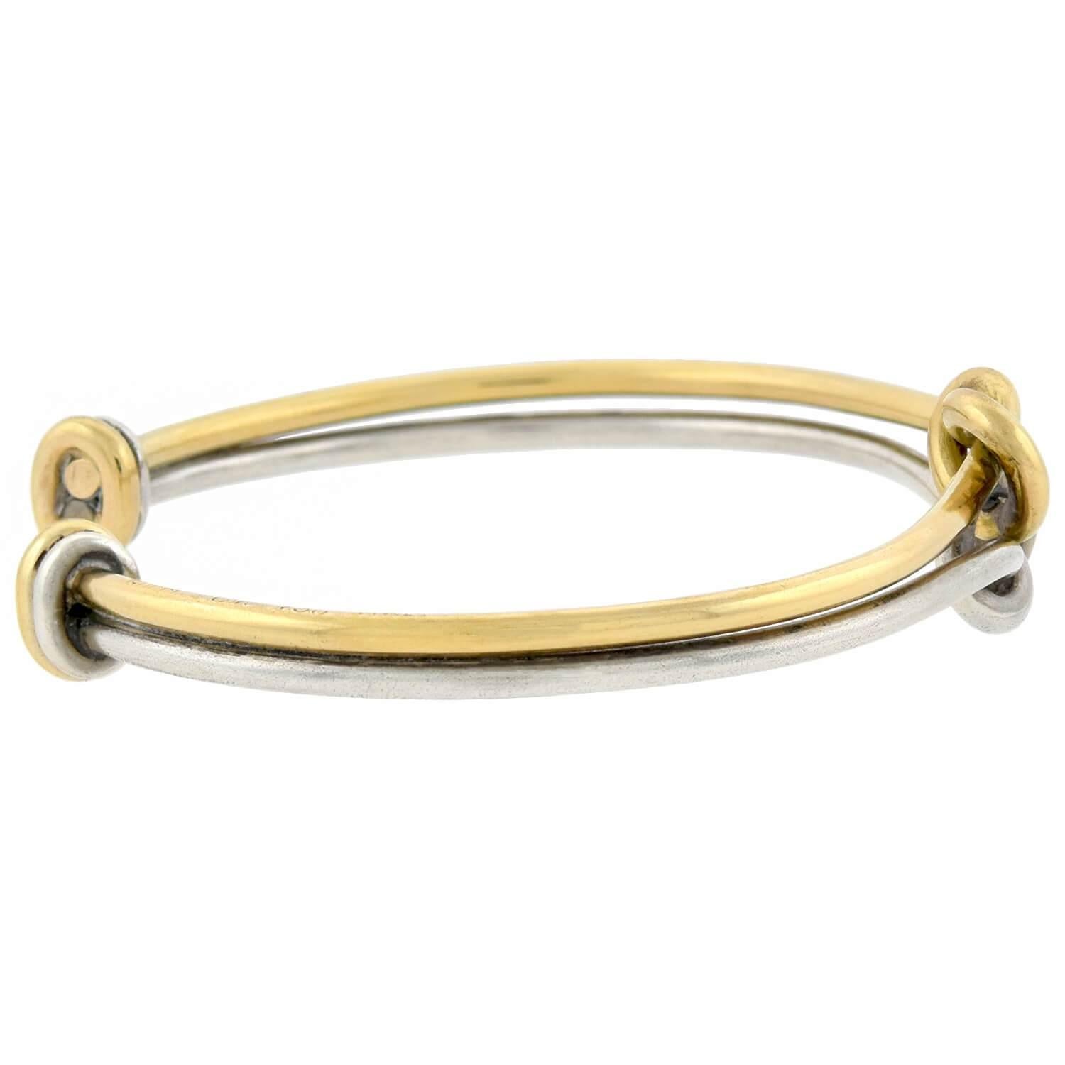 A stunning Estate love knot cuff bracelet from legendary maker Gucci! Crafted in 18kt yellow gold and sterling silver, this gorgeous piece features a large love knot design at its center. The cuff style bracelet is comprised of one gold and one