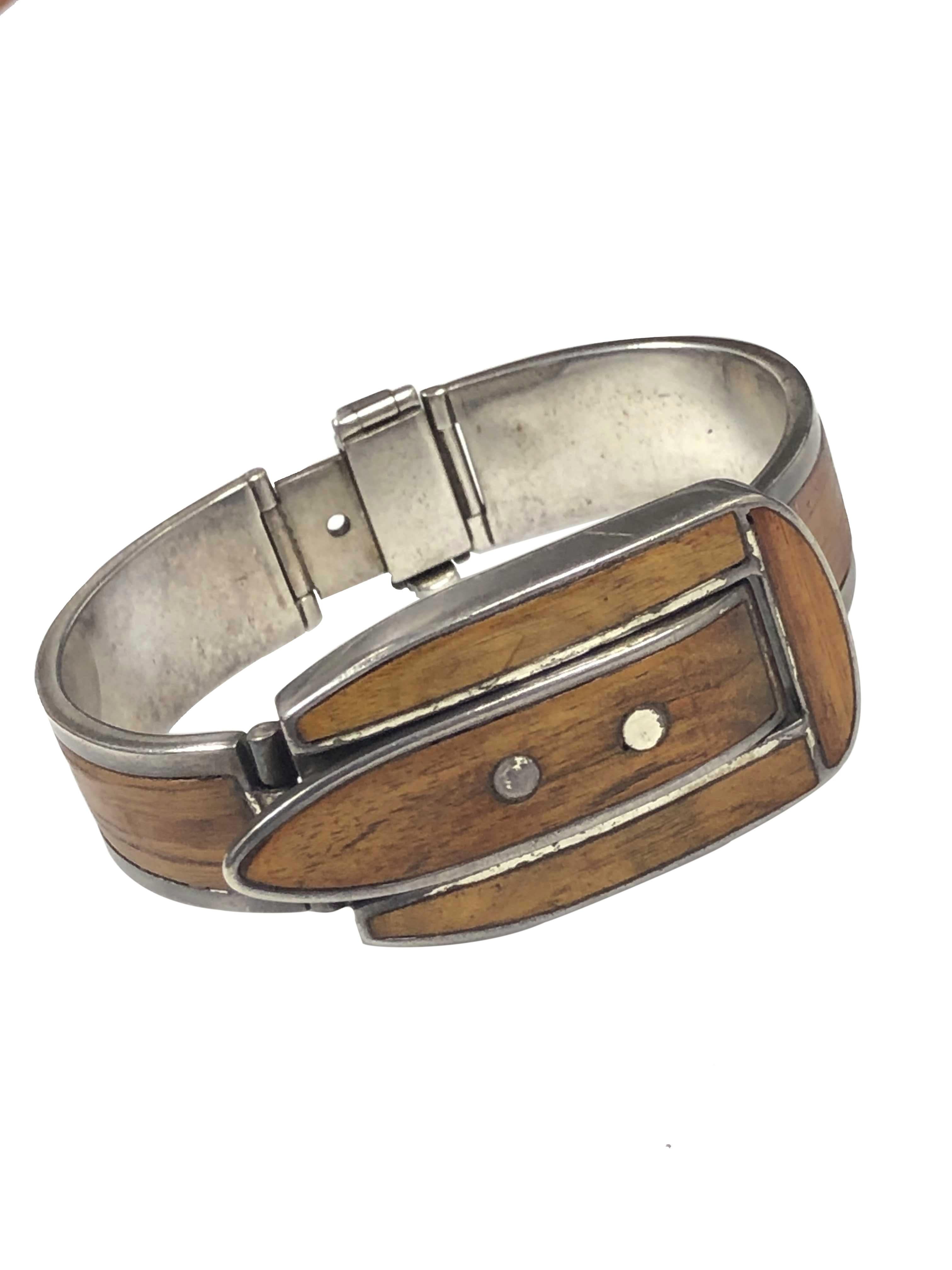 Circa 1960s Gucci Sterling Silver and Wood Bracelet Wrist Watch, the buckle form center section measures 1 3/4 X 1 inch, a simple lift up and snap down cover reveals a White Dial manual wind hidden watch. The 5/8 inch bracelet is set with solid