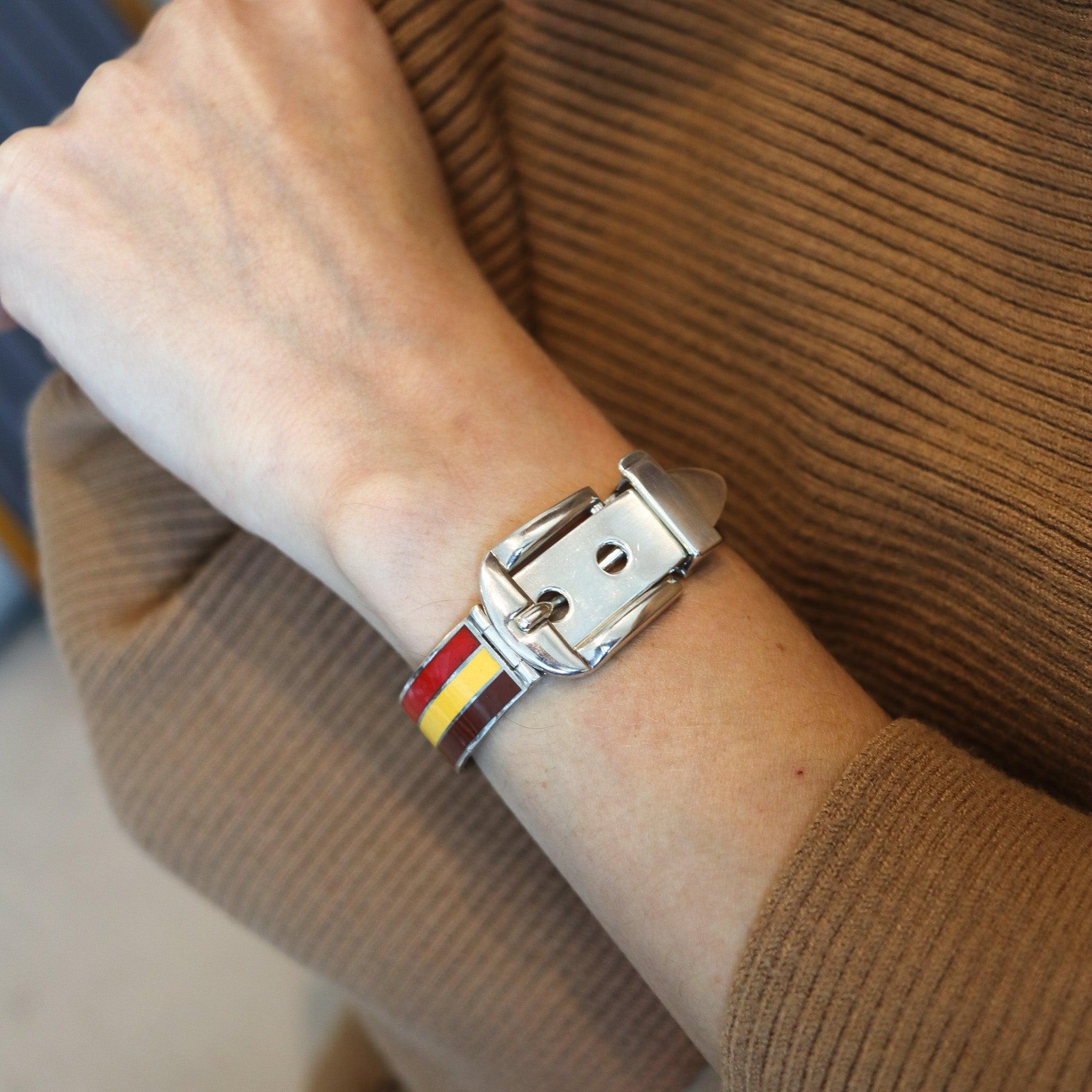 Emailliertes Armband mit Schnalle, entworfen von Gucci.

Dieses ikonische Vintage-Armband mit Schnalle wurde in den 1970er Jahren in Mailand vom Luxushaus Gucci entworfen. Dieses Schnallenarmbandmodell ist selten und wurde aus massivem 925er/999er