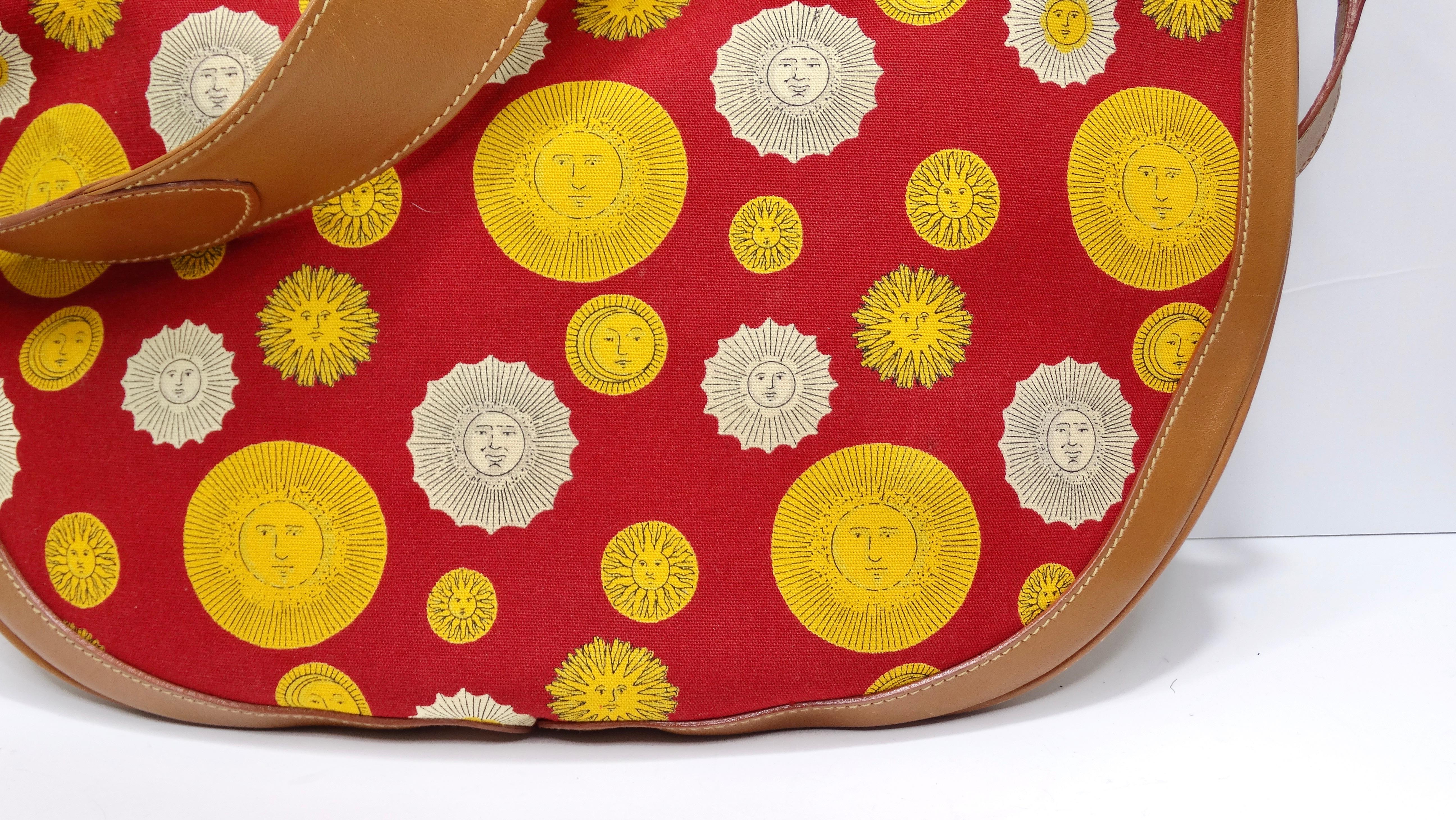 Your new summer bag is giving us Fornasetti vibes! Take a step back in time with this super fun and funky messenger bag from the house of Gucci. The exterior features a canvas sun print in red, cream, and red with rich brown leather detailing, gold