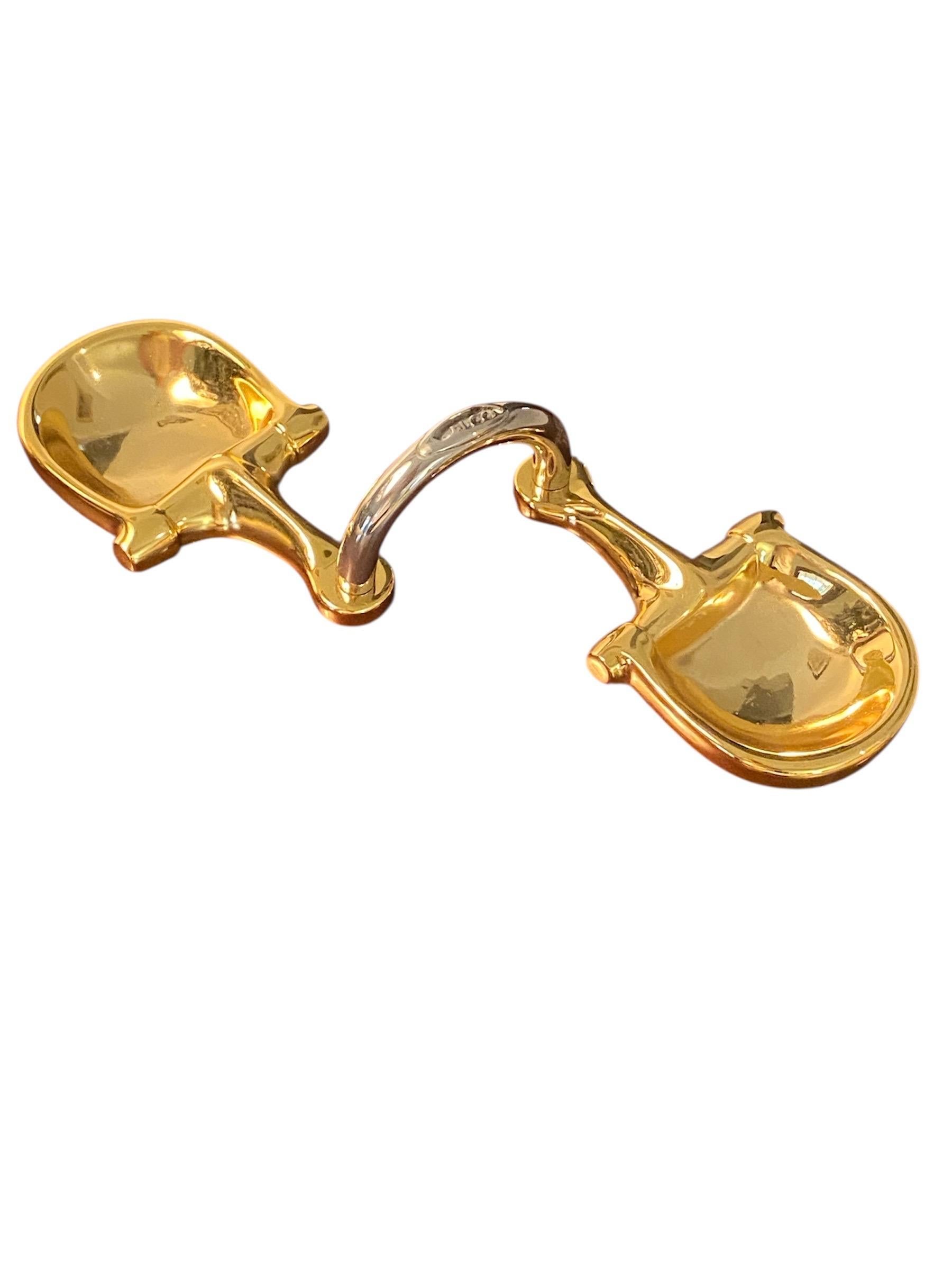Nous vous présentons un plateau à bibelots équestre à double mors de cheval de Gucci of Italy, datant de 1979. On sait qu'il est également utilisé comme cendrier. Les plats en forme de mors de cheval sont coulés en laiton et plaqués en or 24K. La