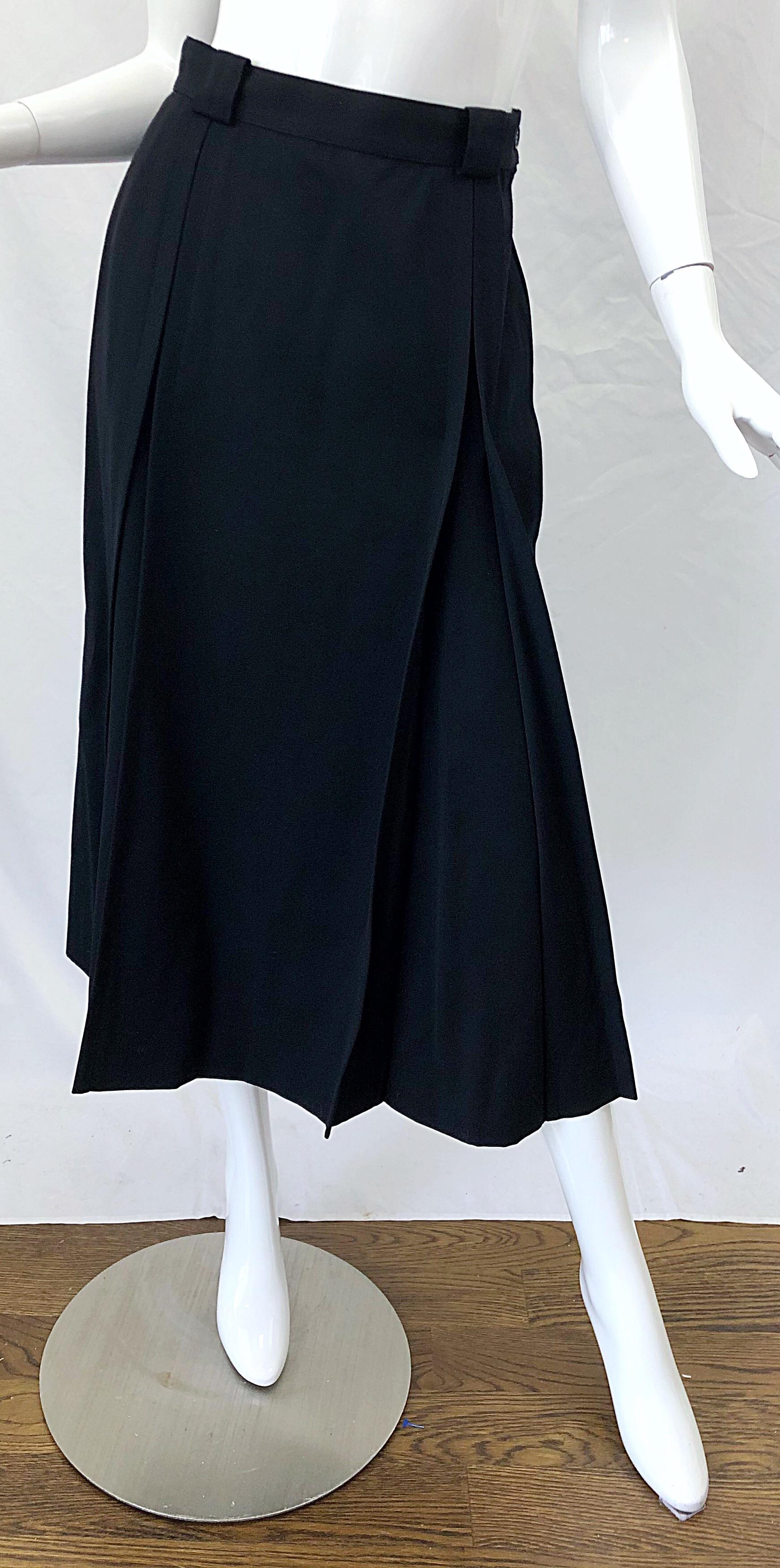 Stylish and classic late 1970s GUCCI black gabardine wool midi skirt ! Features flattering pleats. High waisted fit. Hidden zipper up the side with button closure. Fully lined. The perfect skirt for any time of year. Can easily be dressed up or