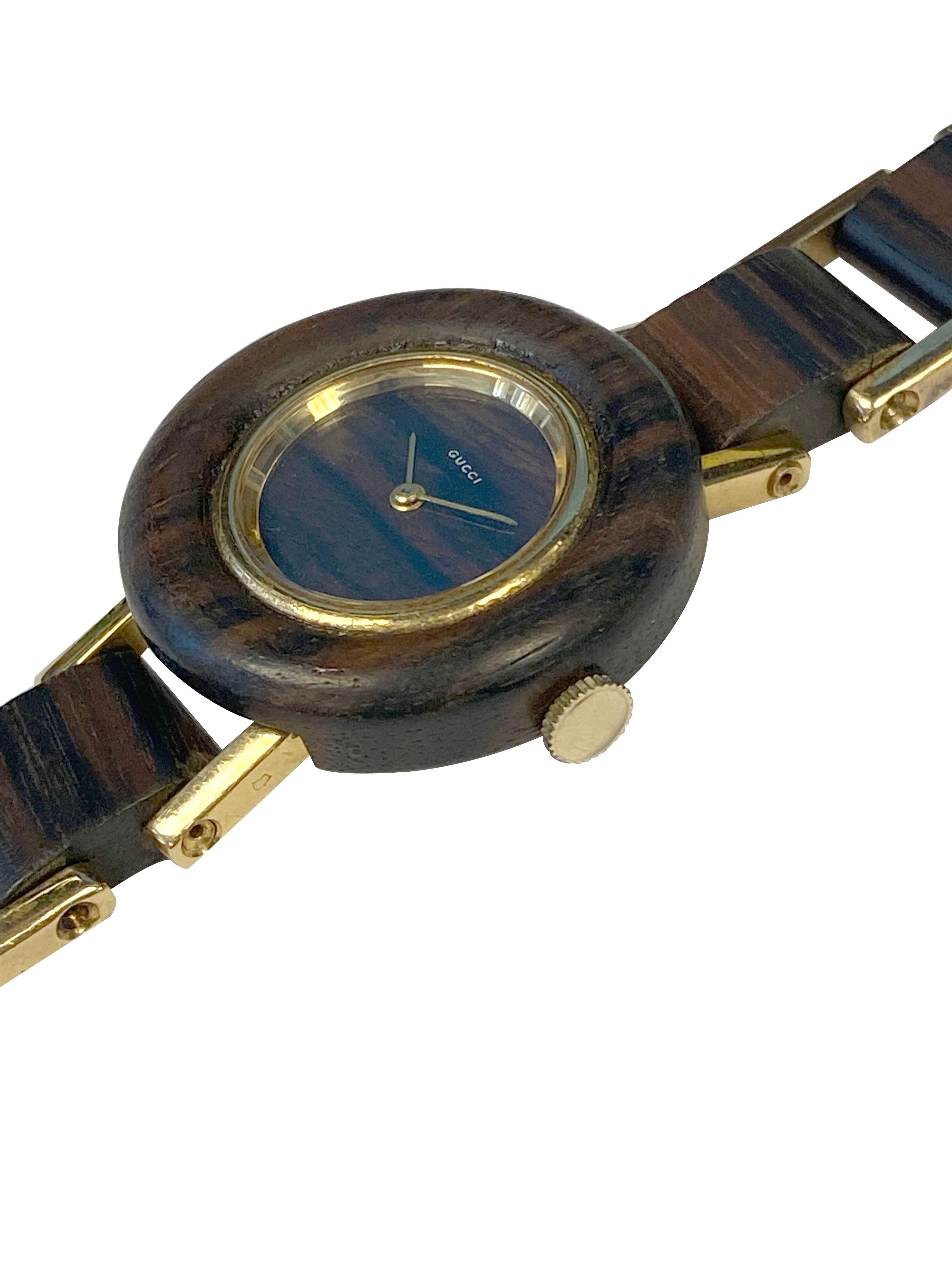 Circa 1970s Gucci Wrist Watch, 33 M.M. 1 piece Solid Wood Case with an 18k Yellow Gold Bezel, Gold case back and Lugs. 17 Jewel Mechanical, Manual wind movement. Solid Wood Dial and Gold Hands. 5/8 inch wide 18K yellow Gold and Wood link Bracelet.