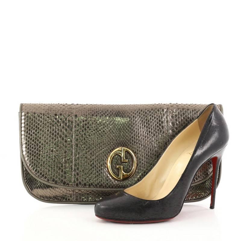 This authentic Gucci 1973 Clutch Python is understated and luxurious. Crafted in genuine pewter python, this chic clutch features double G logo at front flap, and gold-tone hardware accents. Its magnetic snap button closure opens to a black
