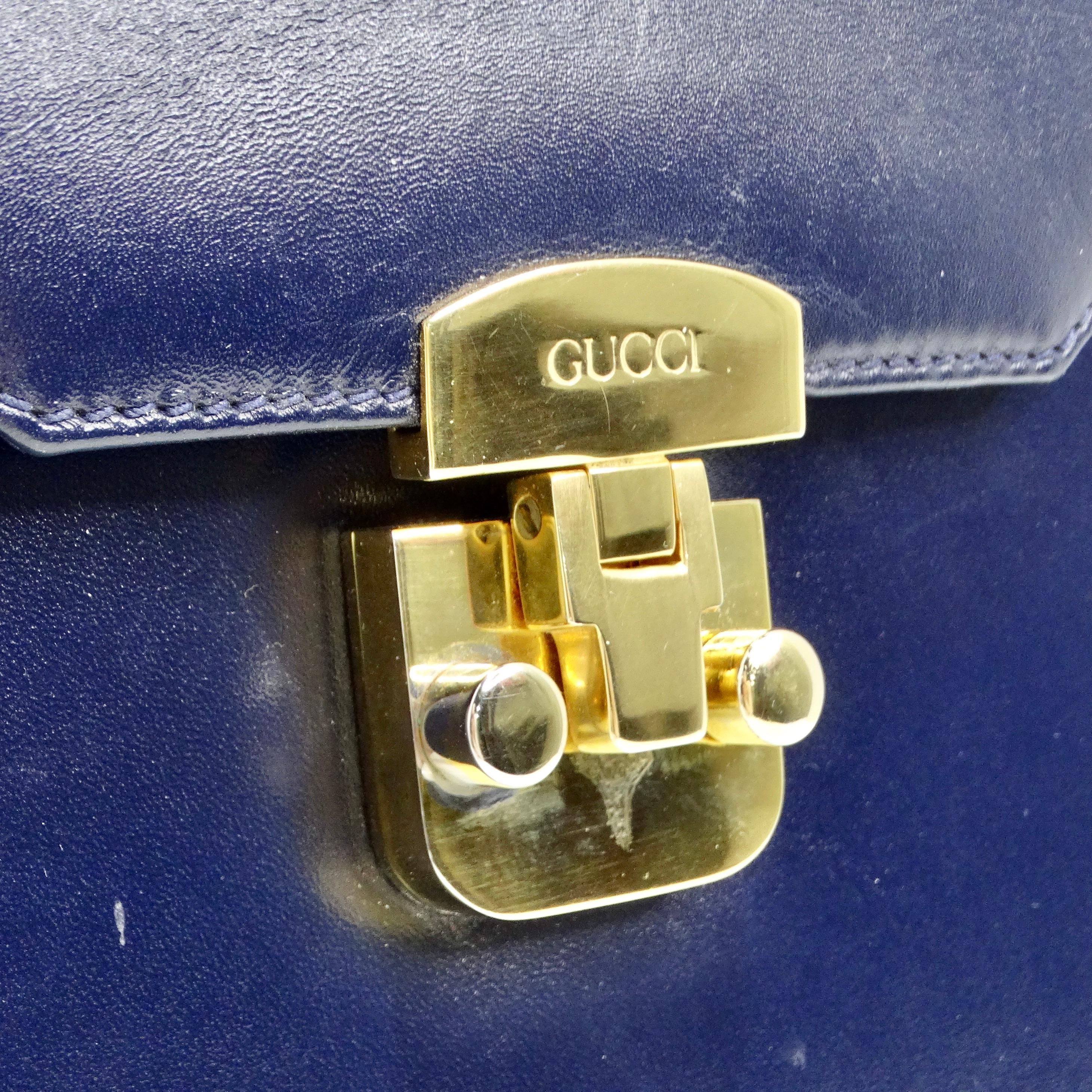The Gucci 1980s Lady Lock Navy Leather Handbag is a stunning and elegant accessory that exudes sophistication and timeless style. Crafted from navy blue leather, this structured handbag features a classic top handle design that adds a touch of