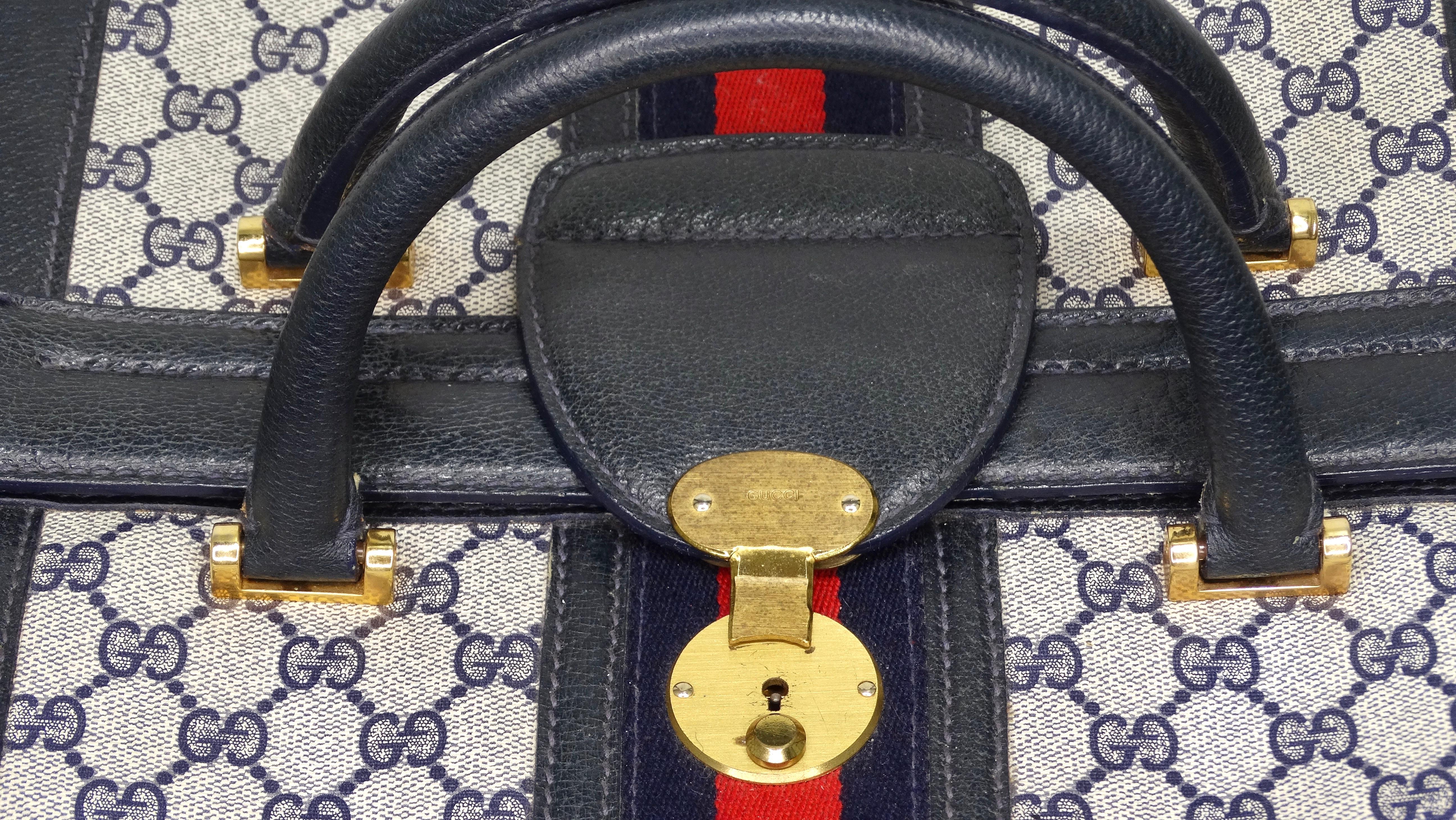 Travel in style in this cool 1980's vintage three-lock train case from the house of Gucci. The exterior is covered in a 'GG' blue and grey monogram canvas and complimented with navy blue leather, gold hardware, and a red and blue stripe. Features a